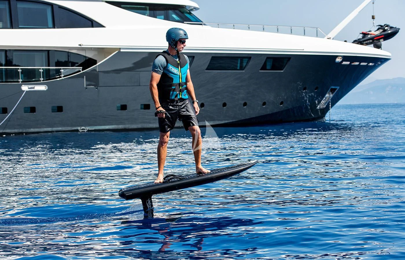 a person standing on a surfboard in the water aboard ZIA Yacht for Sale