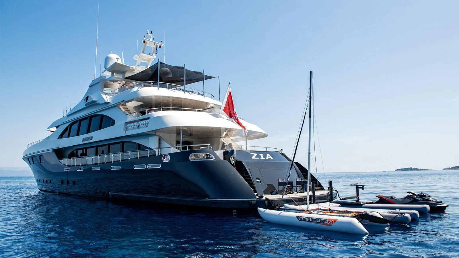 a large boat with a flag on it aboard ZIA Yacht for Sale