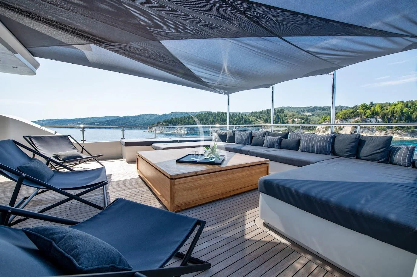 a room with a couch and a table with a view of the water aboard ZIA Yacht for Sale