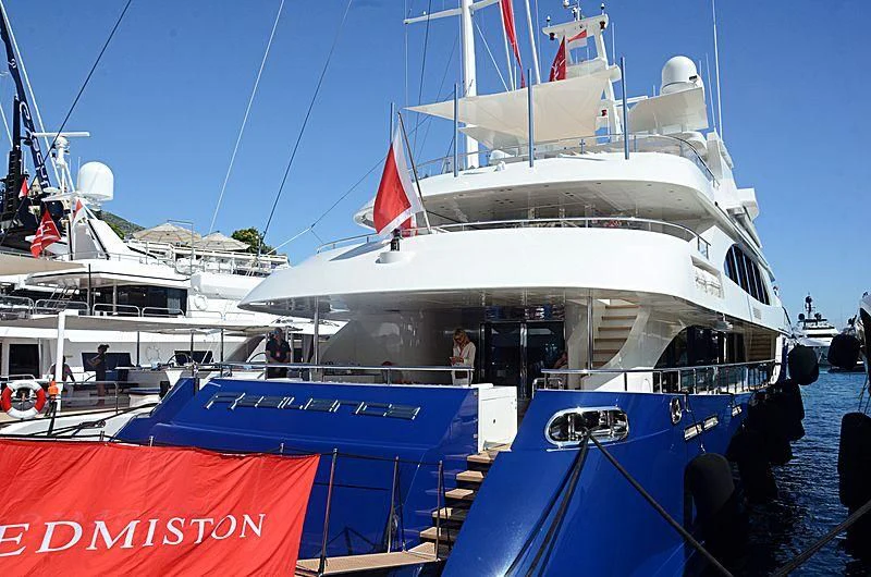 a large white boat with red and blue flags on it aboard ZIA Yacht for Sale