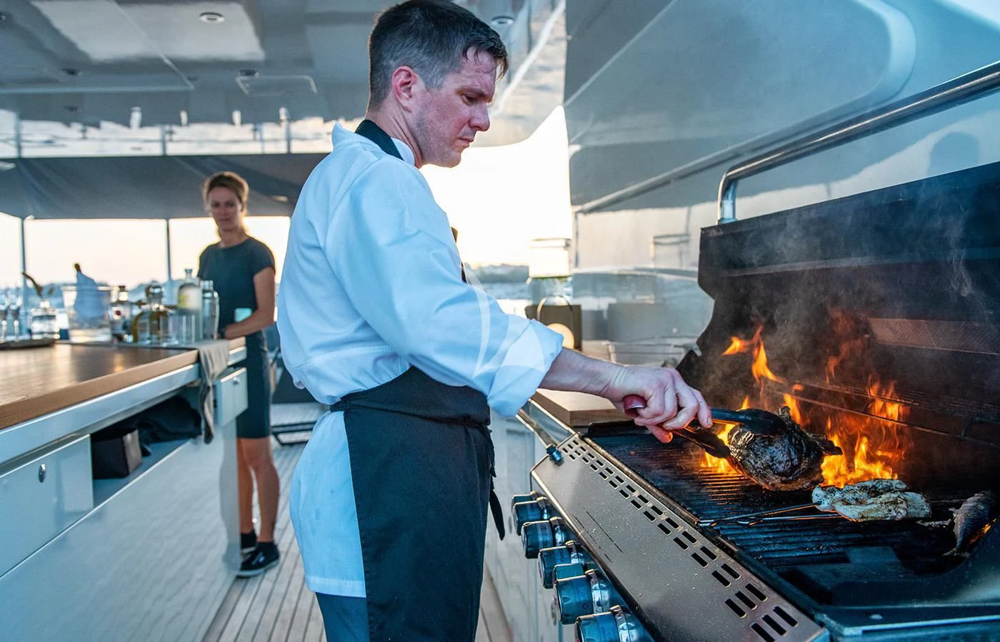 a man cooking food in a restaurant aboard ZIA Yacht for Sale