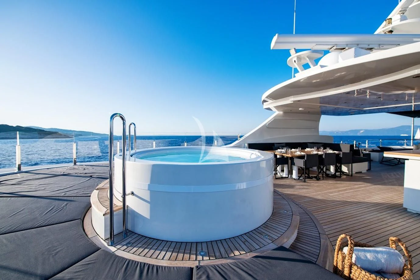 a glass of water next to an airplane on a deck aboard ZIA Yacht for Sale
