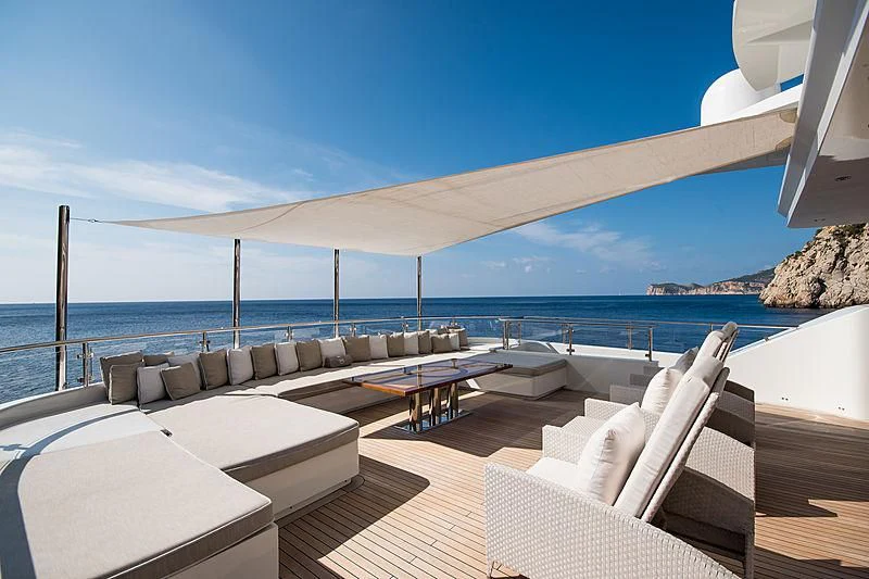 a large lounge area with a large body of water in the background aboard ZIA Yacht for Sale