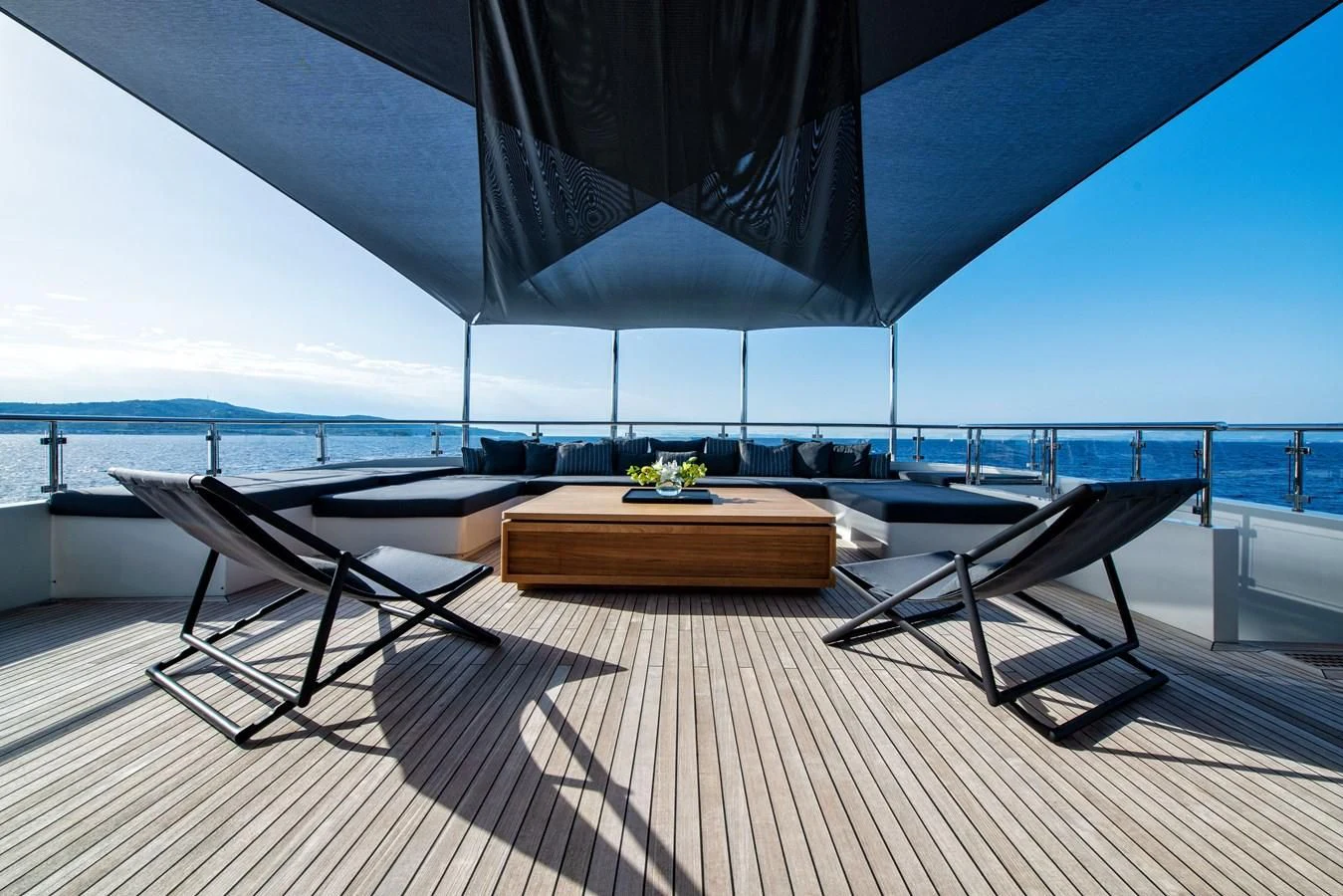 a deck with a table and chairs on it aboard ZIA Yacht for Sale