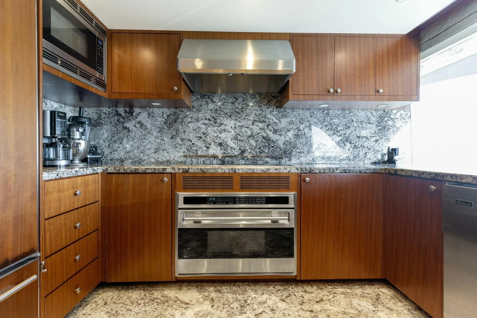 a kitchen with wooden cabinets aboard CLAYMAKER Yacht for Sale