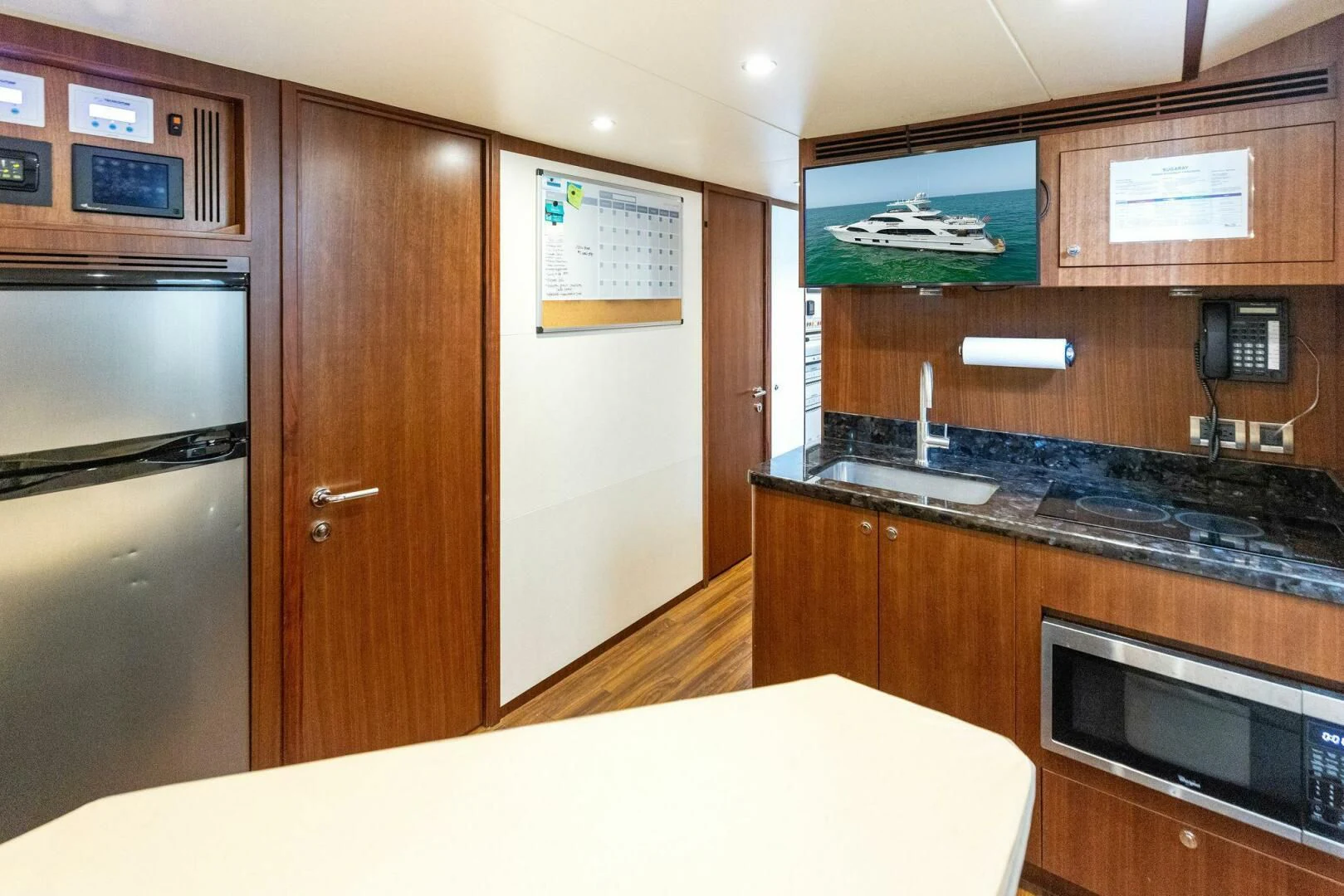 a kitchen with wooden cabinets aboard CLAYMAKER Yacht for Sale