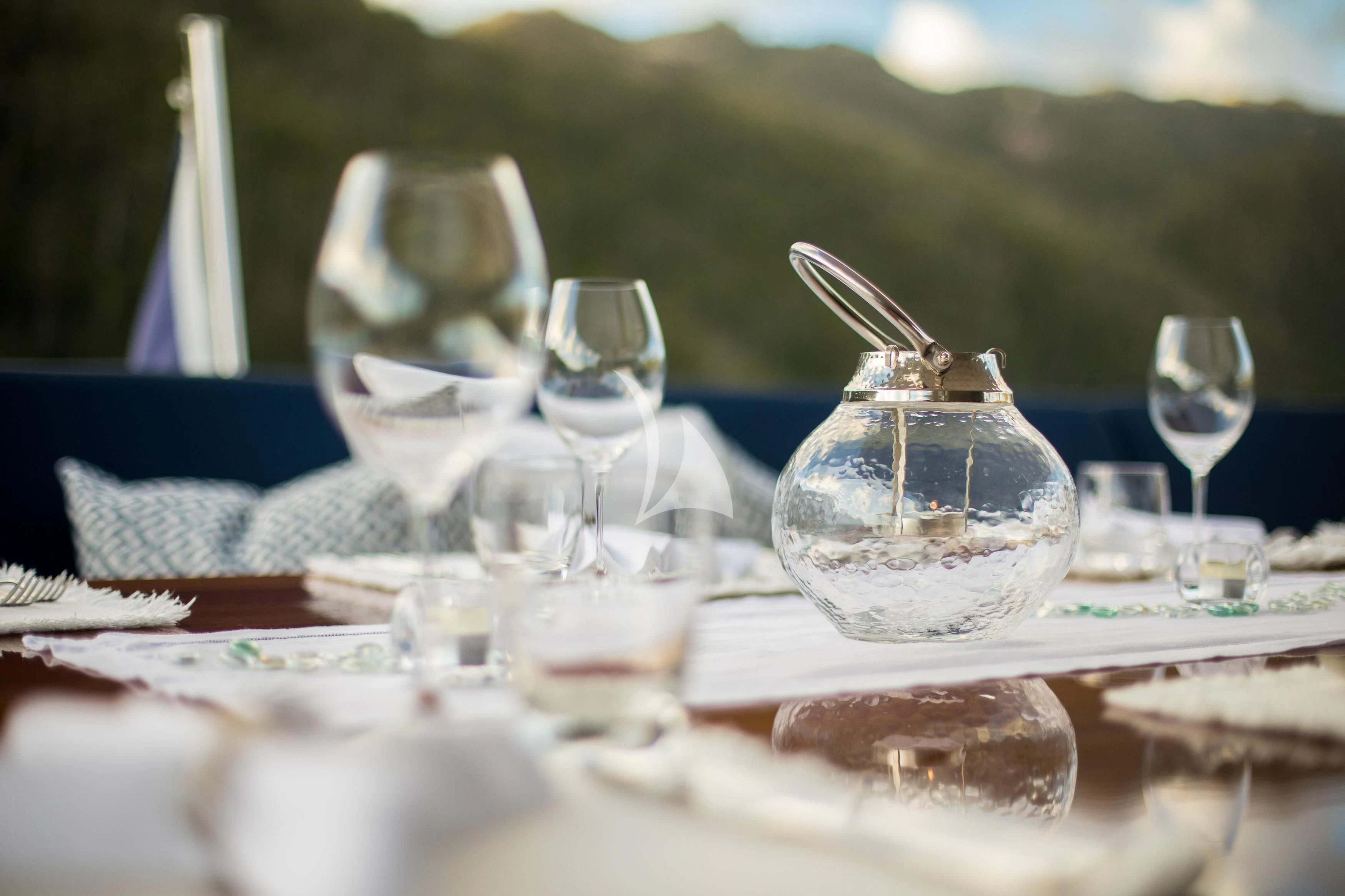 a table with glasses and plates aboard DE LISLE III Yacht for Sale