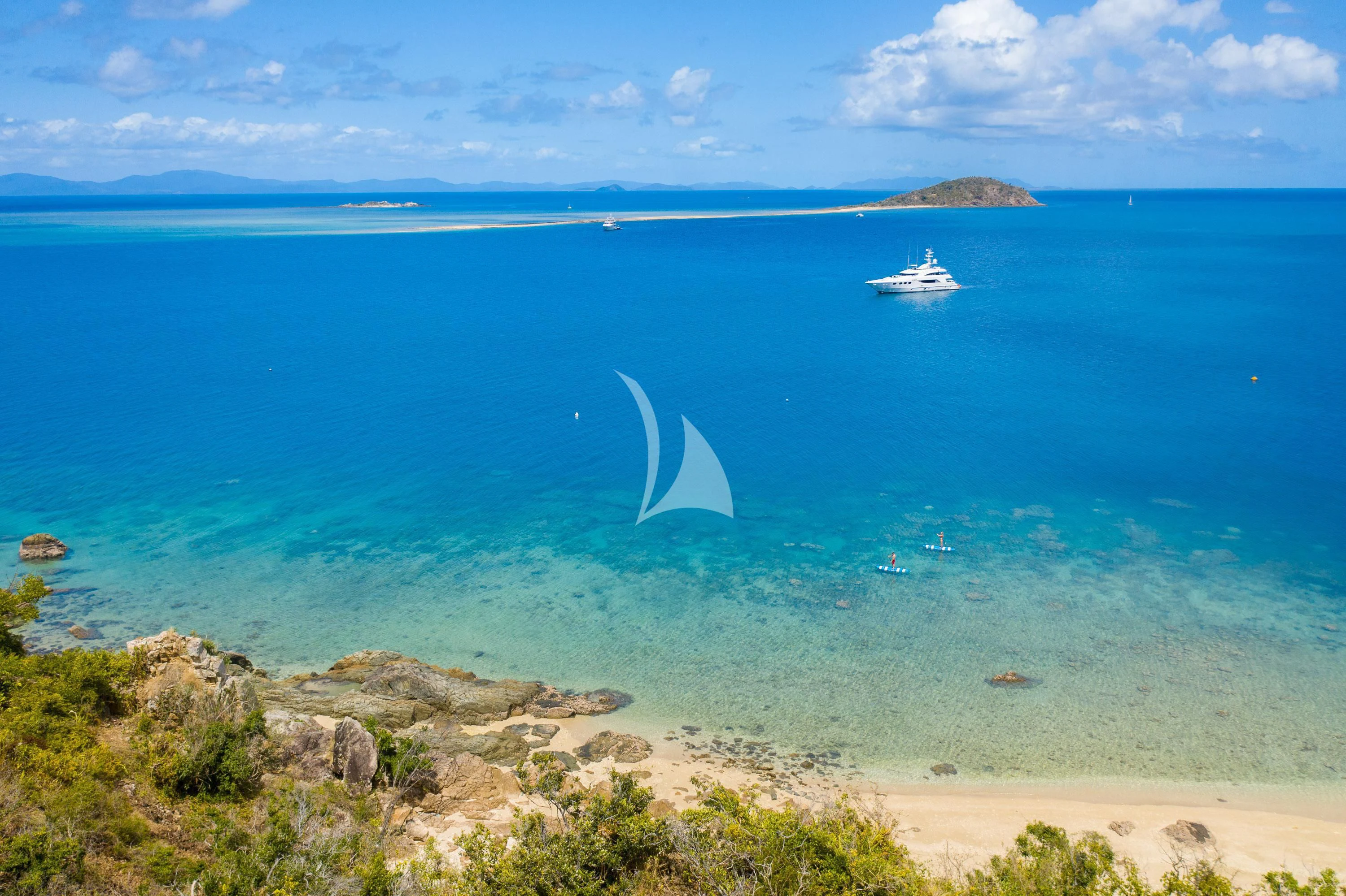 a body of water with a sandy beach and a boat in the water aboard DE LISLE III Yacht for Sale
