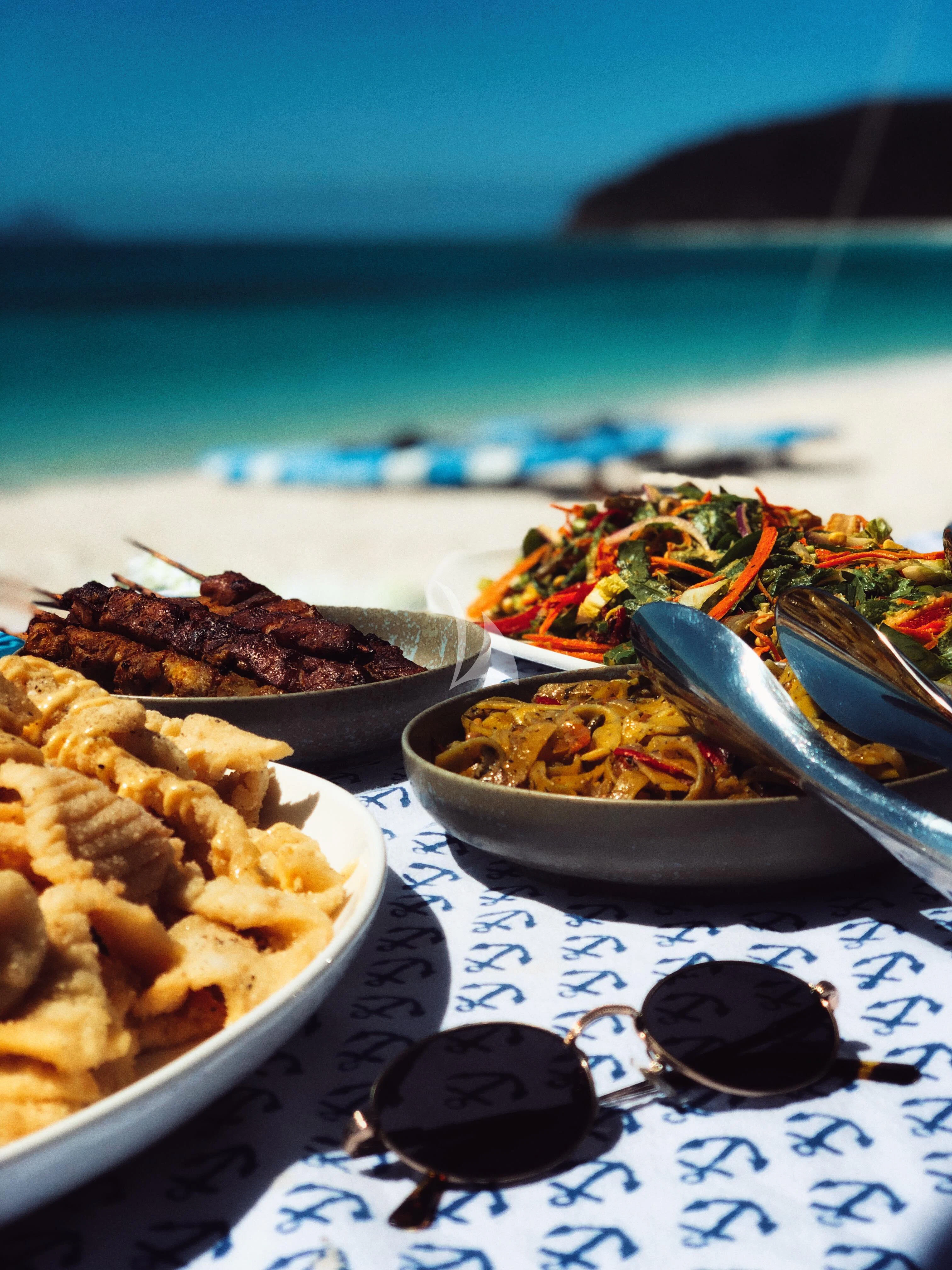 a table with plates of food on it aboard DE LISLE III Yacht for Sale