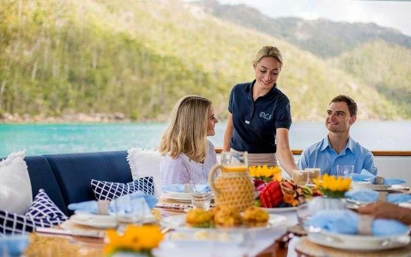 a family sitting at a table aboard DE LISLE III Yacht for Sale