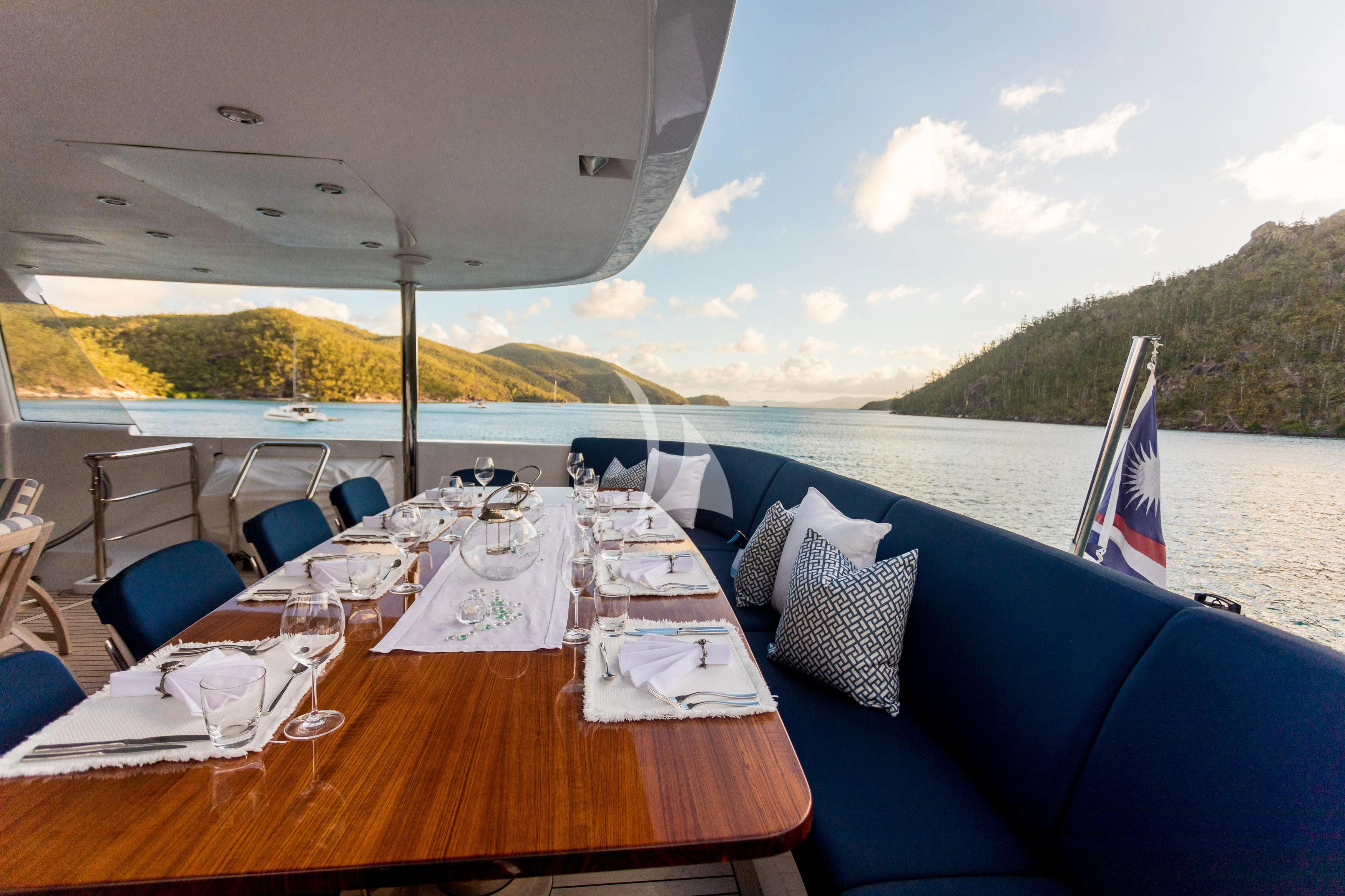 a table with chairs and umbrellas on it aboard DE LISLE III Yacht for Sale