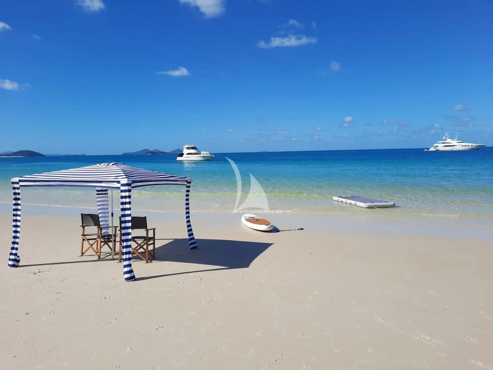 a chair and a table on a beach aboard DE LISLE III Yacht for Sale