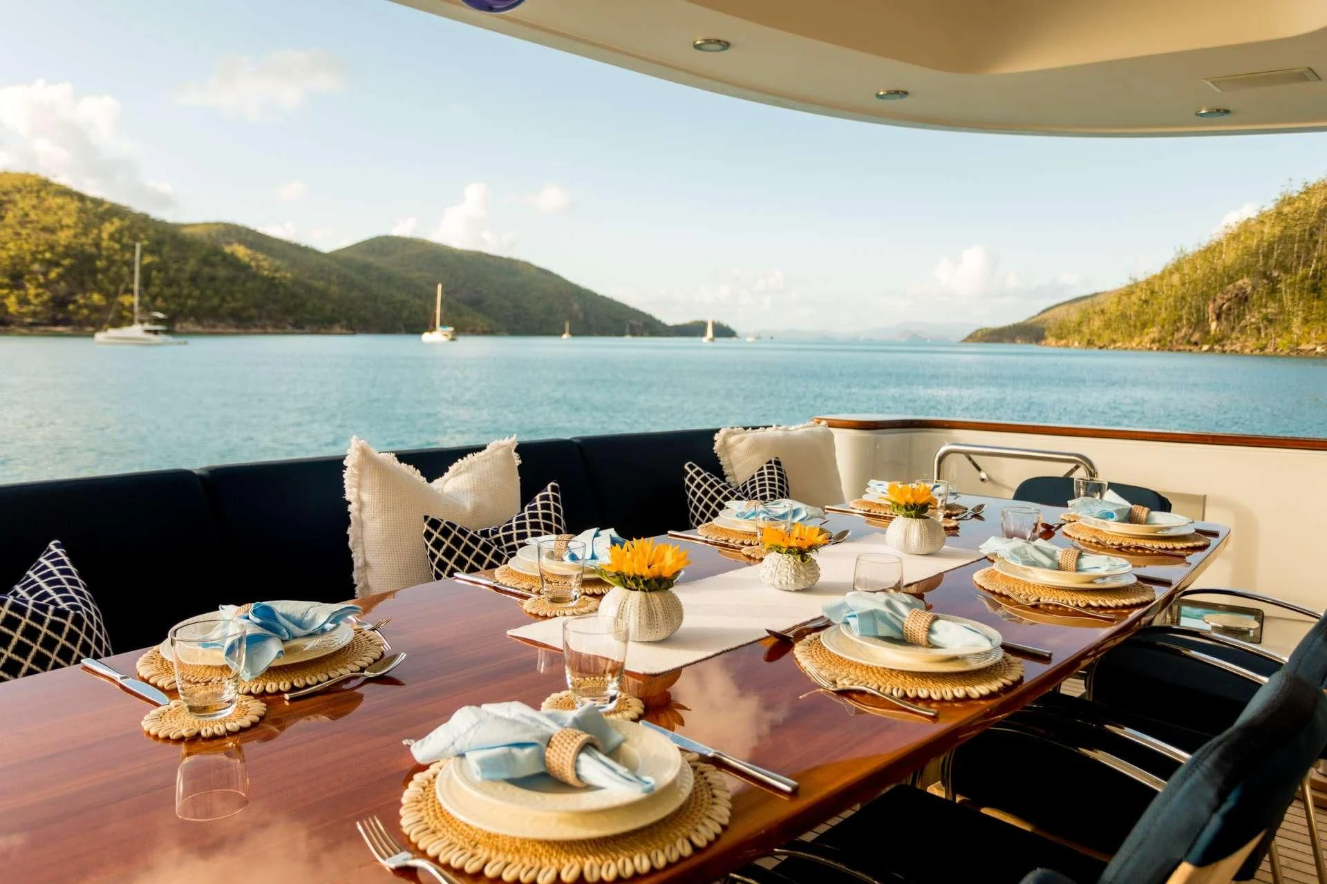 a table with plates and glasses on it by a body of water aboard DE LISLE III Yacht for Sale
