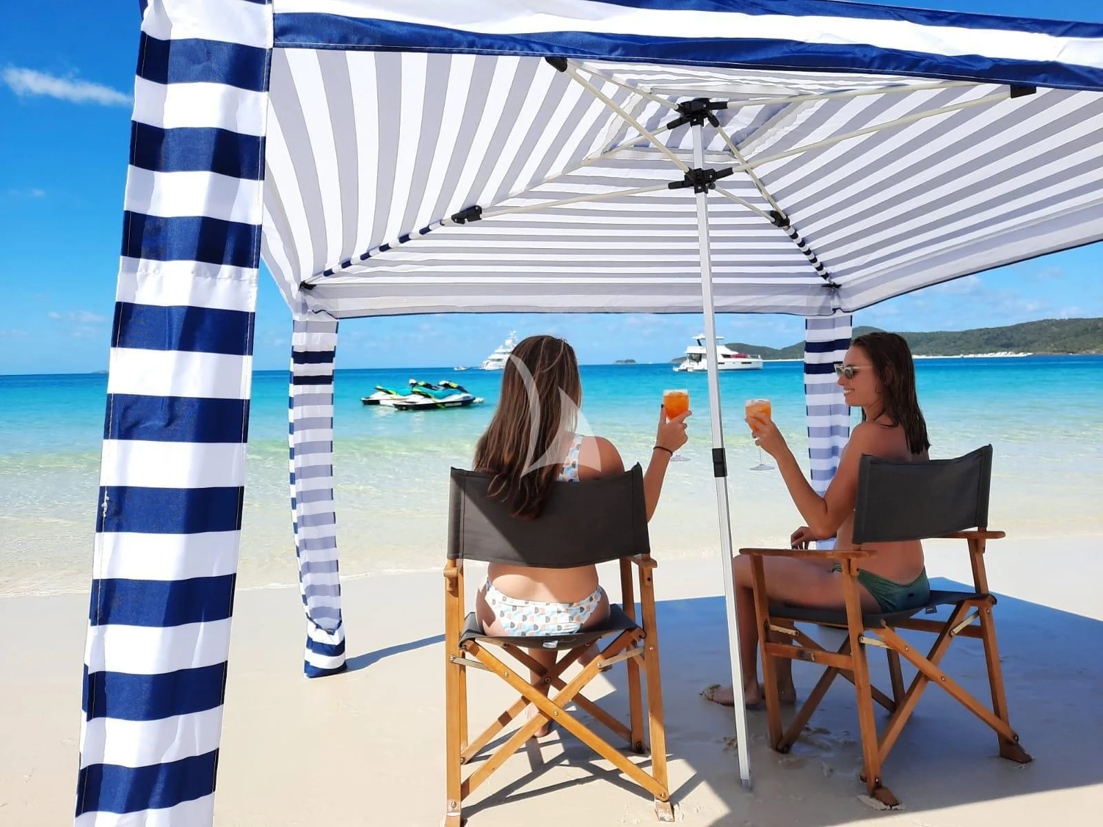 two women sitting under a white umbrella aboard DE LISLE III Yacht for Sale
