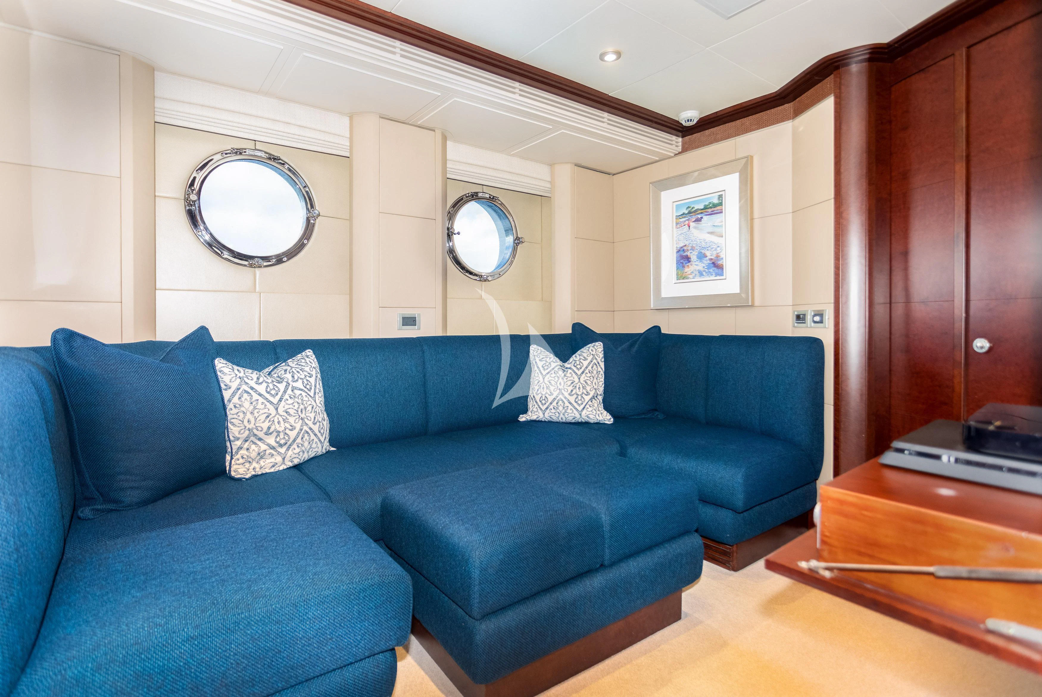 a living room with a blue couch aboard DE LISLE III Yacht for Sale