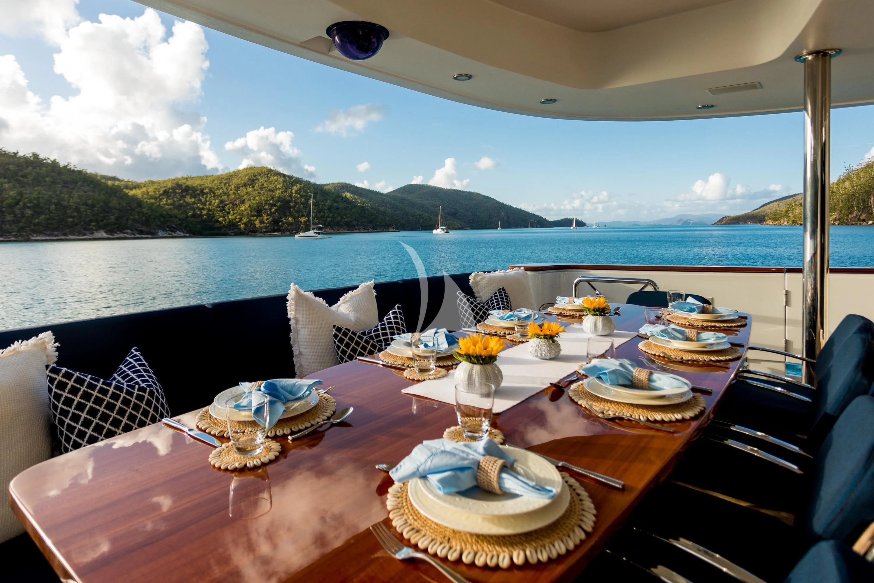 a table with plates and glasses on it by a body of water aboard DE LISLE III Yacht for Sale