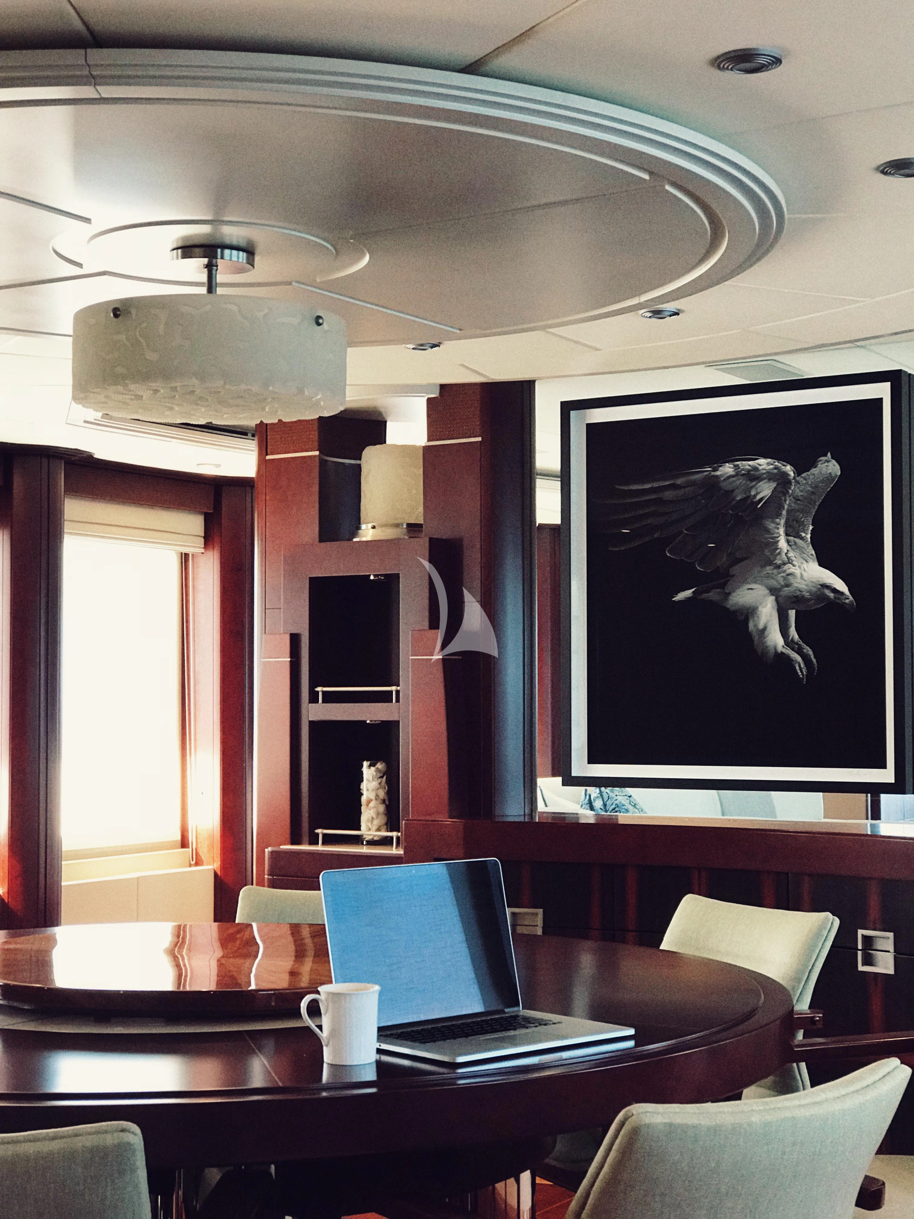 a room with a table and chairs and a tv on the wall aboard DE LISLE III Yacht for Sale