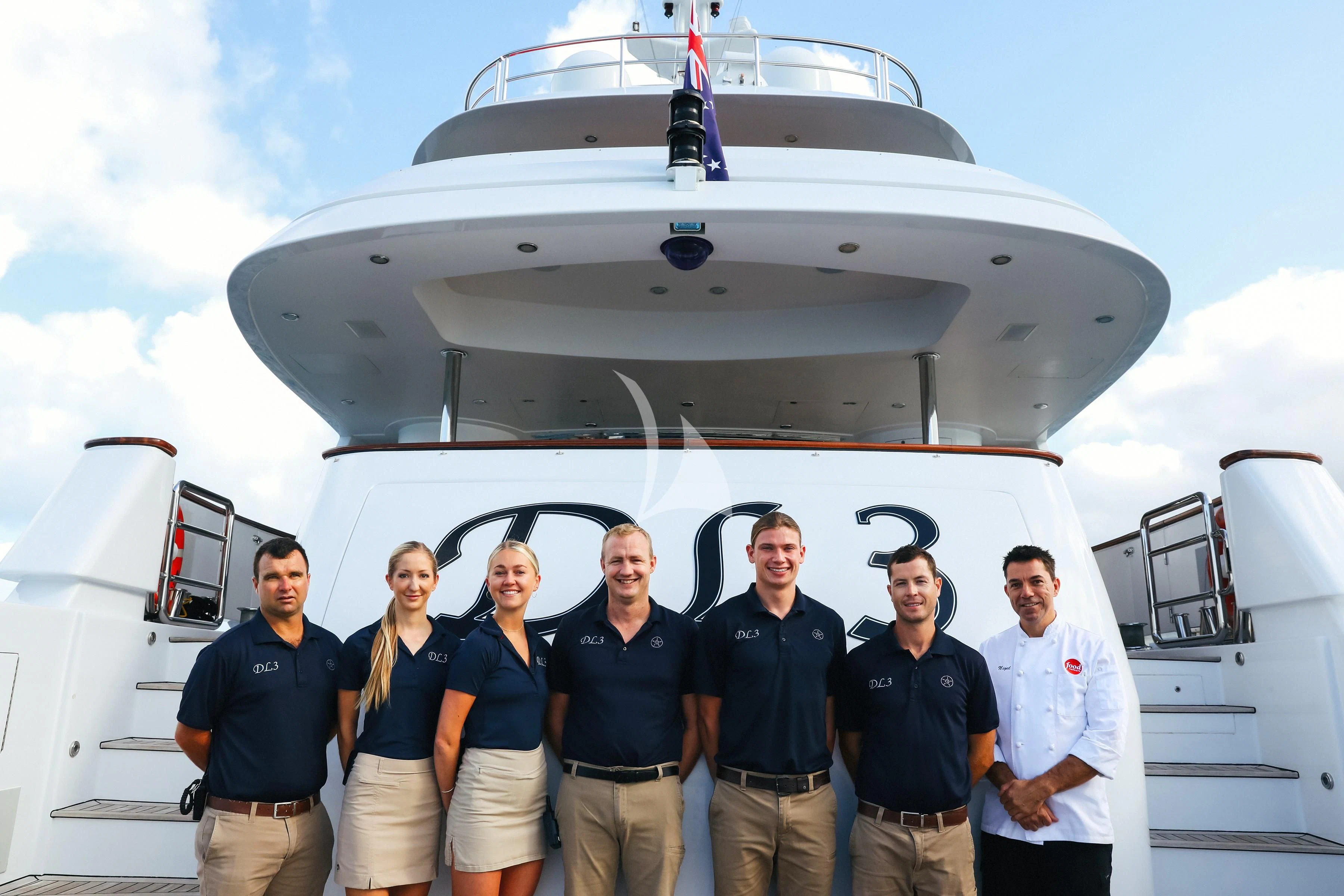a group of people posing for a photo in front of a white plane aboard DE LISLE III Yacht for Sale