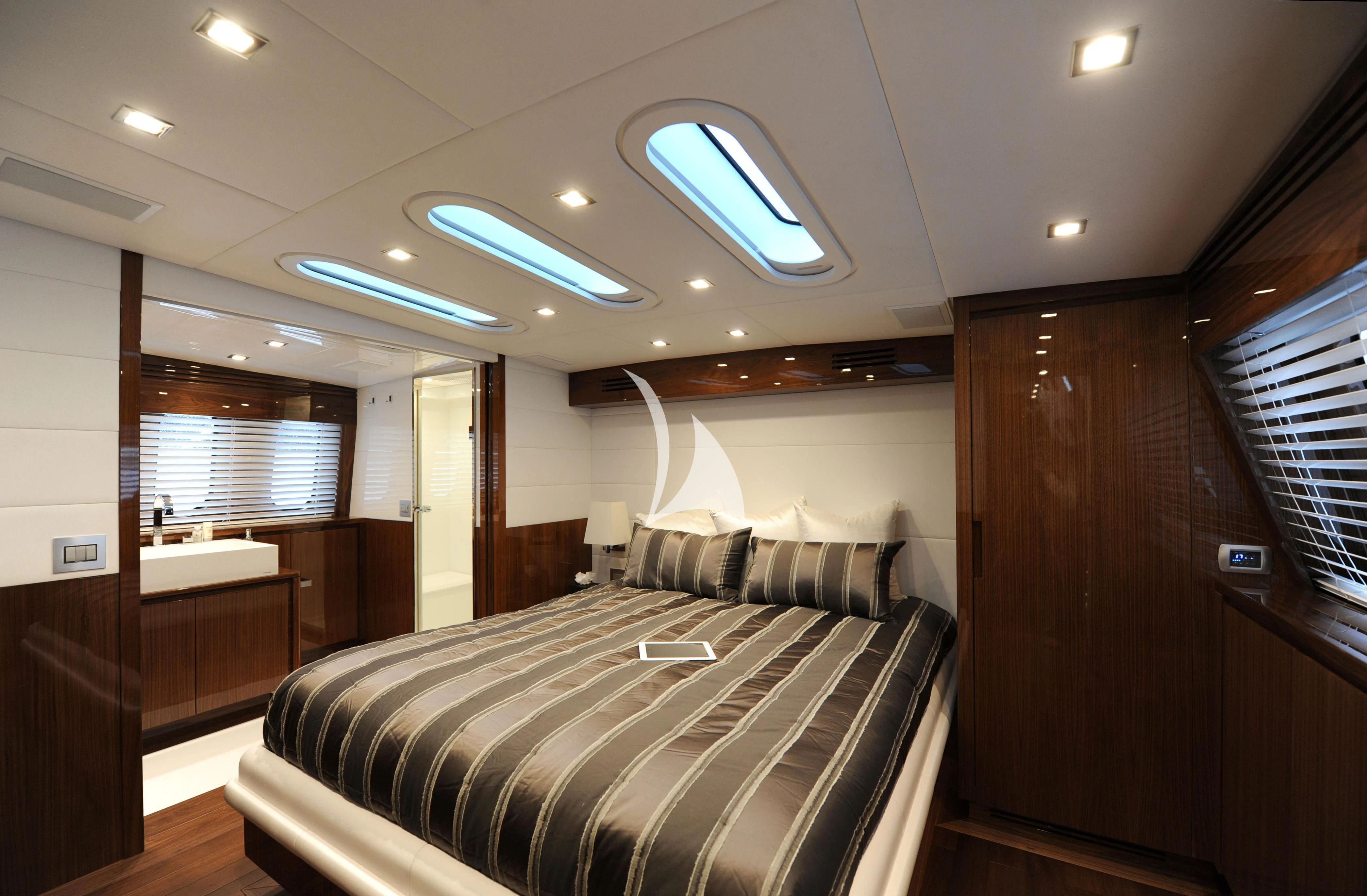 a bedroom with a bed and a wood door aboard PHOENICIAN Yacht for Sale