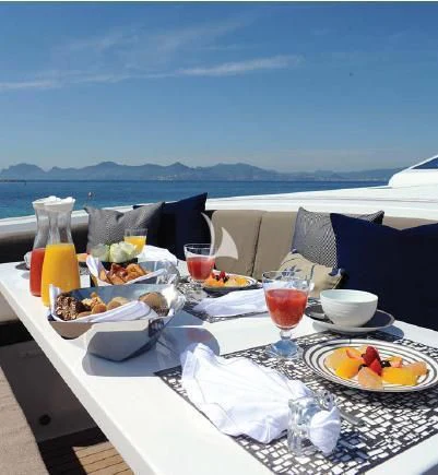 a table with food and drinks on it aboard PHOENICIAN Yacht for Sale