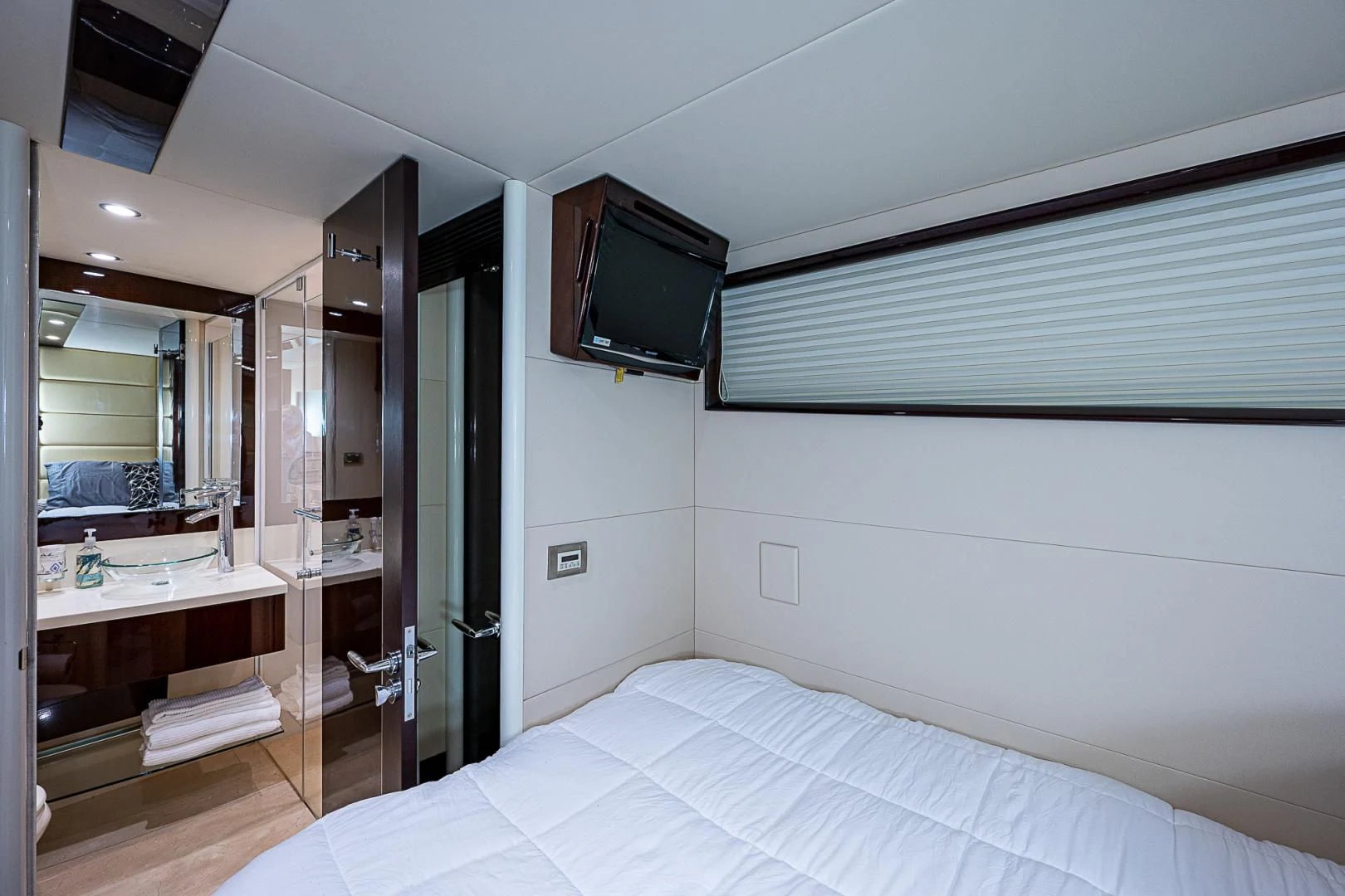 a bedroom with a bed and a television on the wall aboard LATITUDE Yacht for Sale