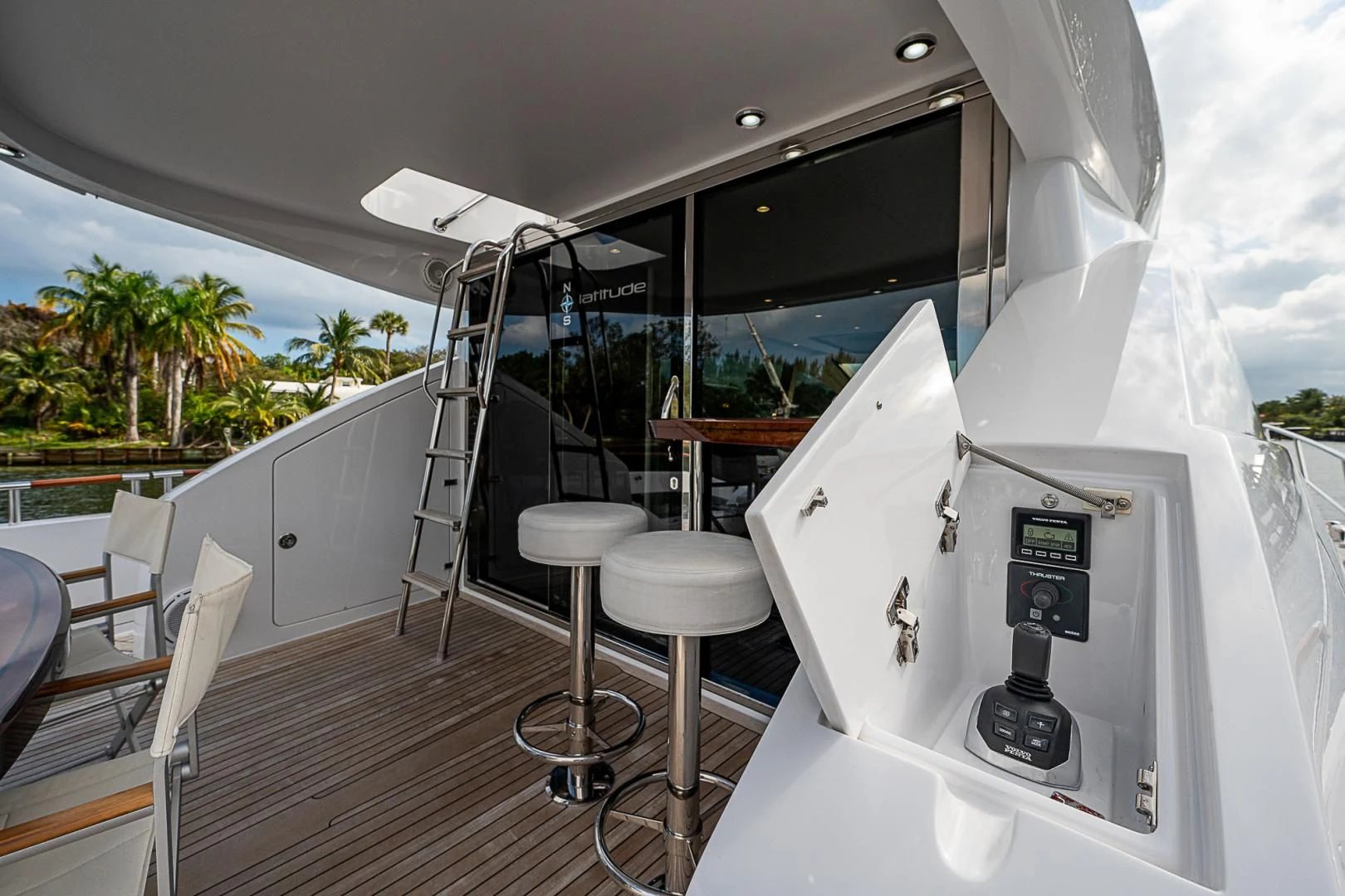 a white boat with a black bar and stools on a deck aboard LATITUDE Yacht for Sale