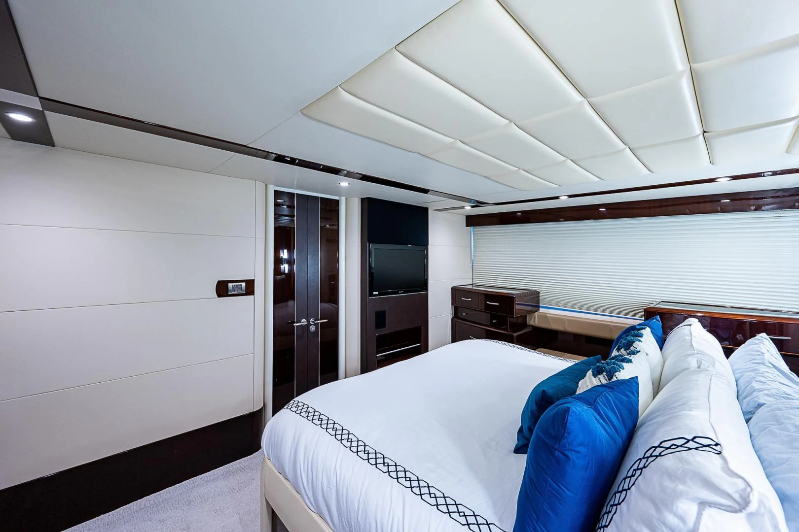 a room with a bed and a television aboard LATITUDE Yacht for Sale