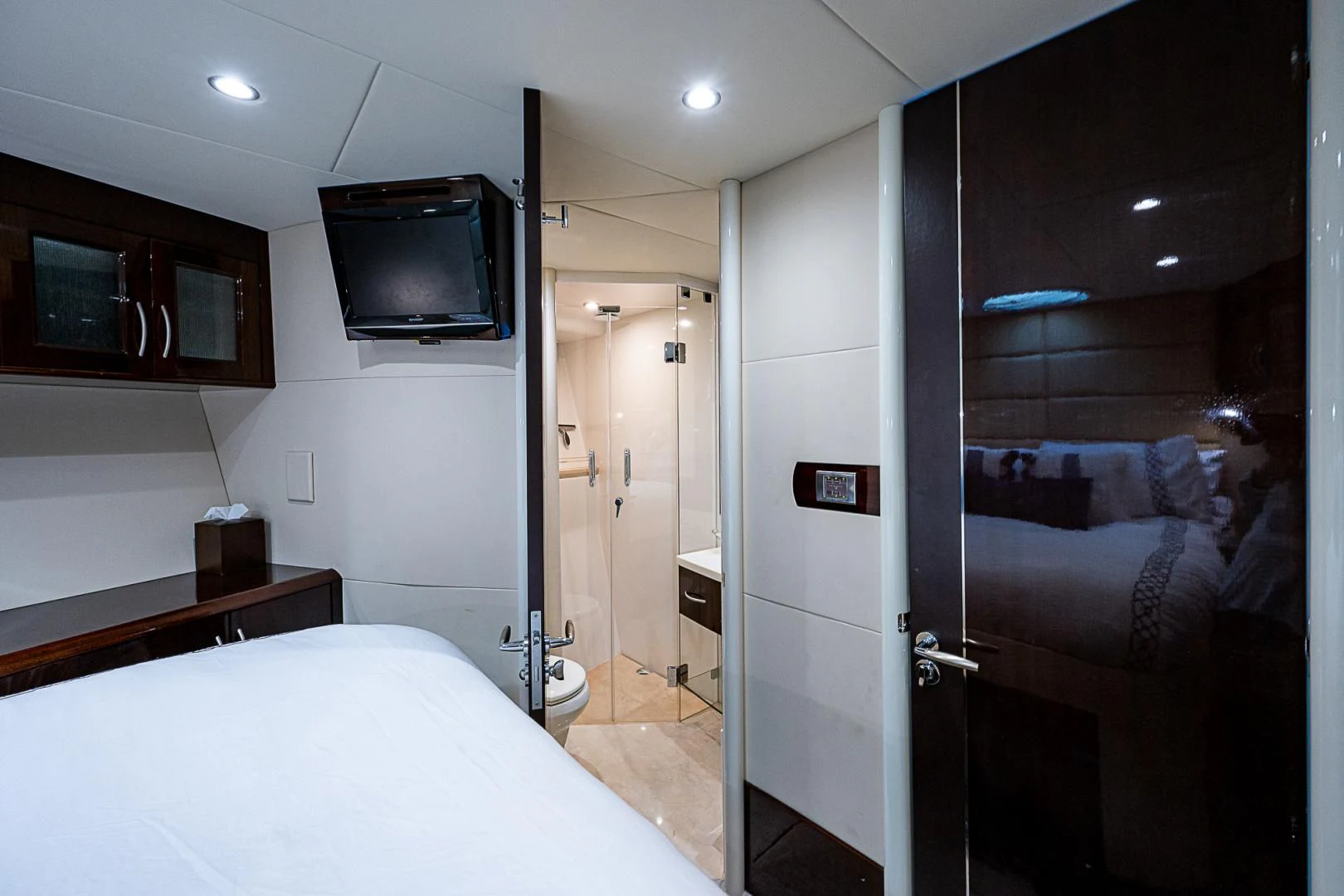 a bedroom with a bed and a television aboard LATITUDE Yacht for Sale