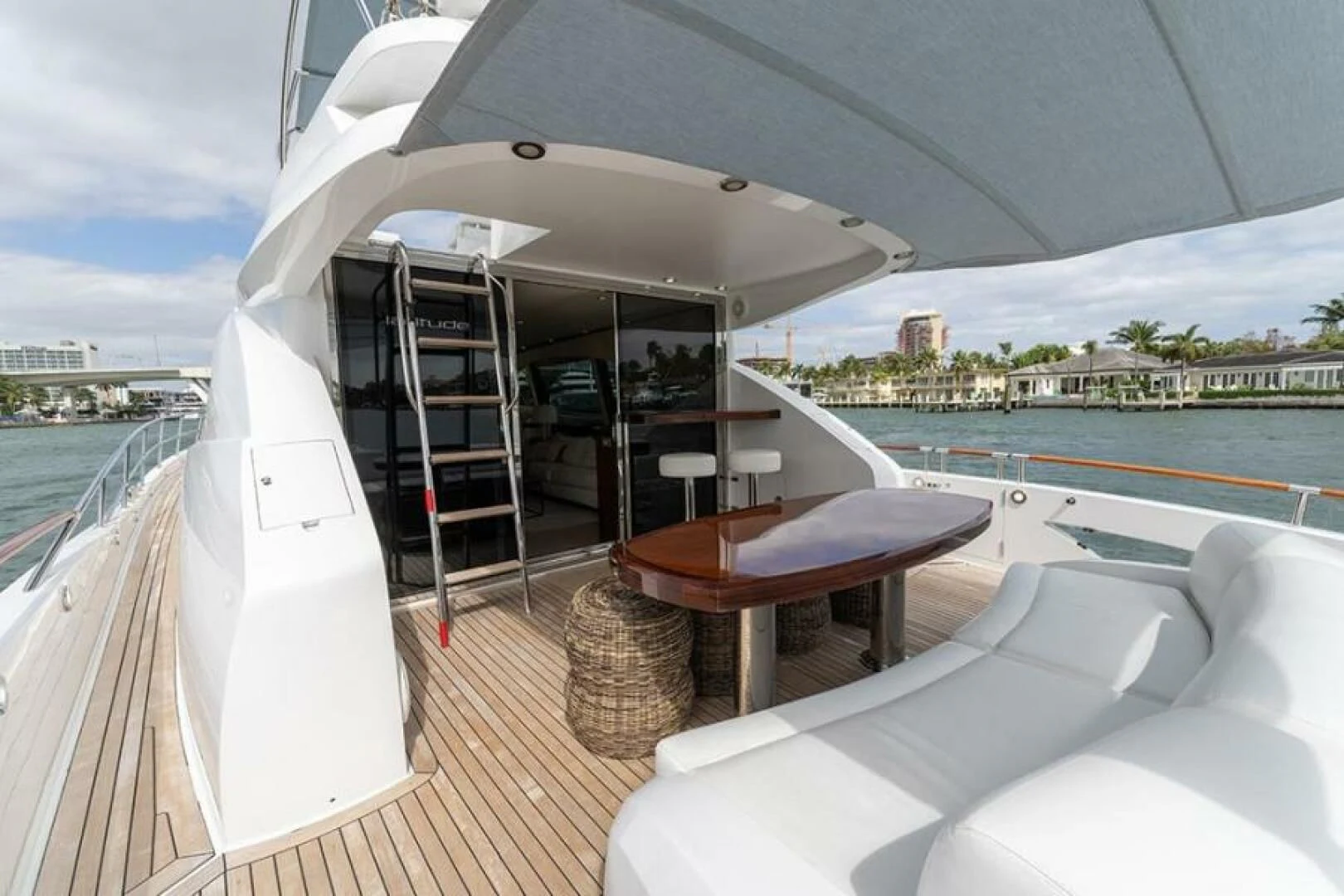 a deck with a table and chairs on it by the water aboard LATITUDE Yacht for Sale