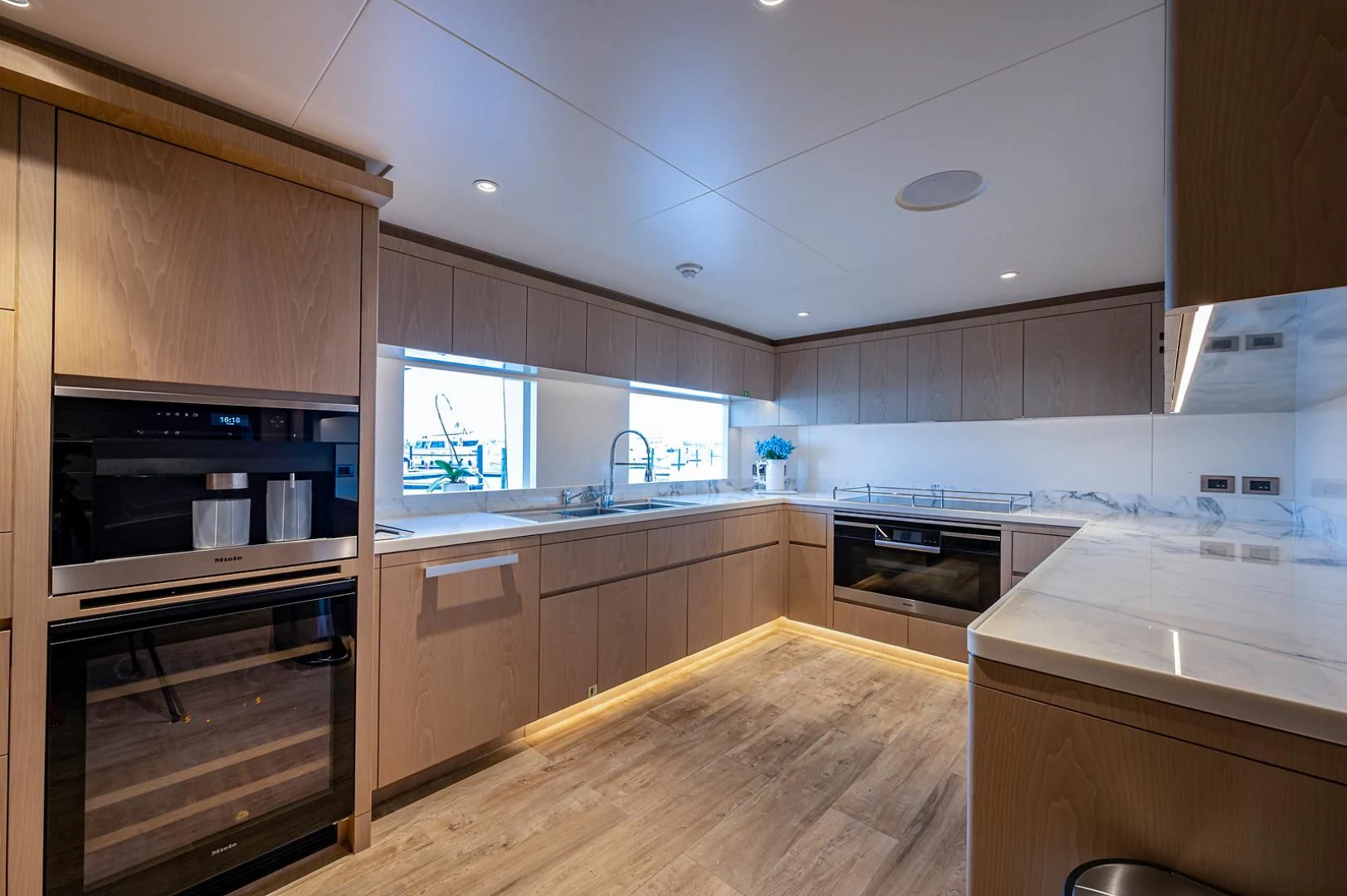a kitchen with wooden cabinets aboard LIRA Yacht for Sale