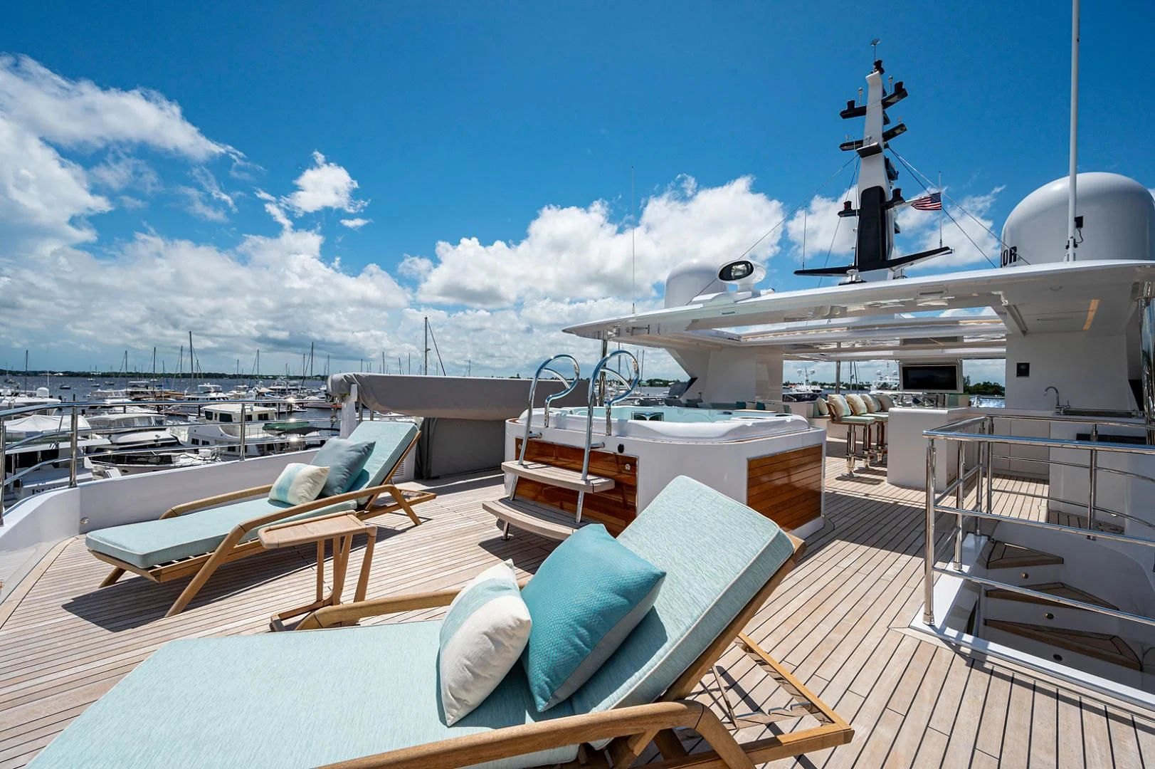 a deck with a deck and a large ship in the water aboard LIRA Yacht for Sale