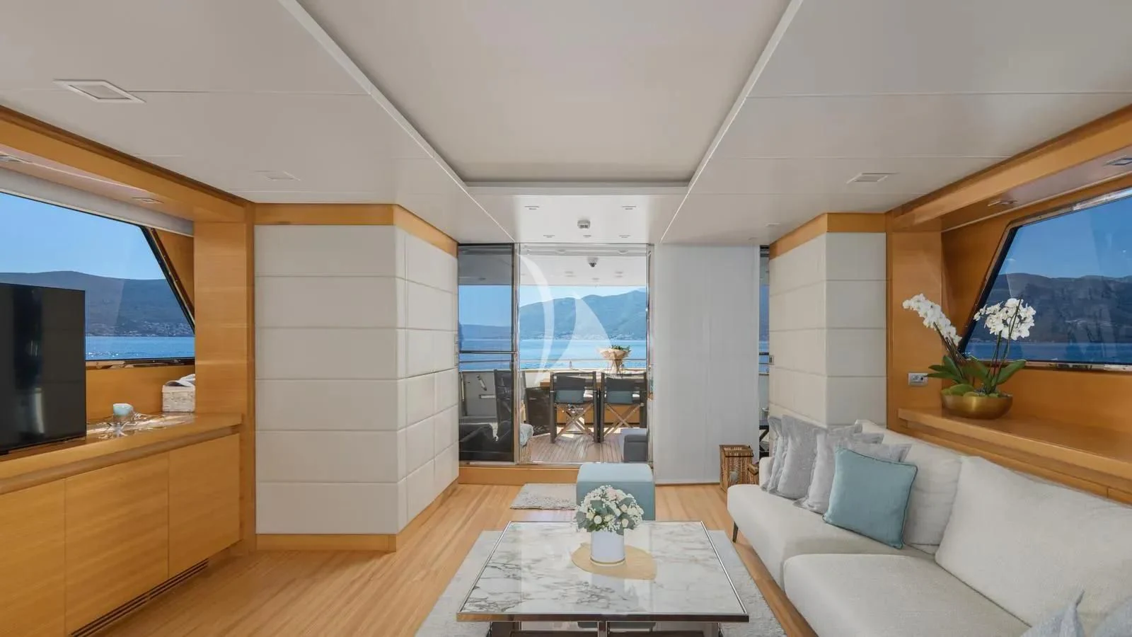 a living room with a table and couches aboard PERTULA Yacht for Sale