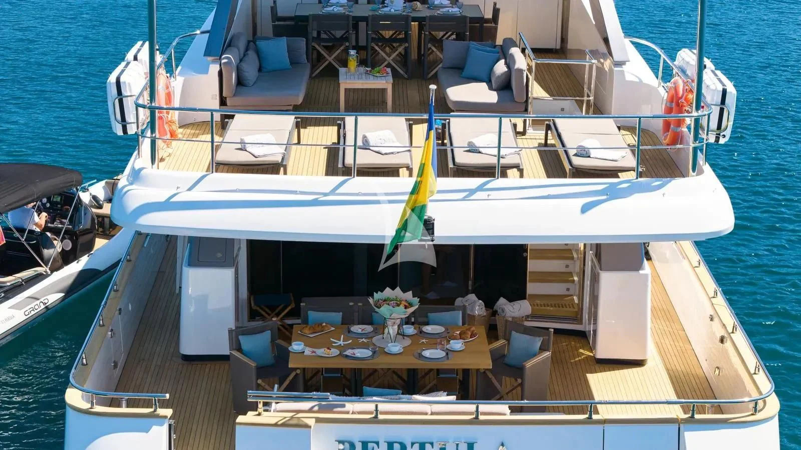 a boat with a table and chairs on the deck aboard PERTULA Yacht for Sale