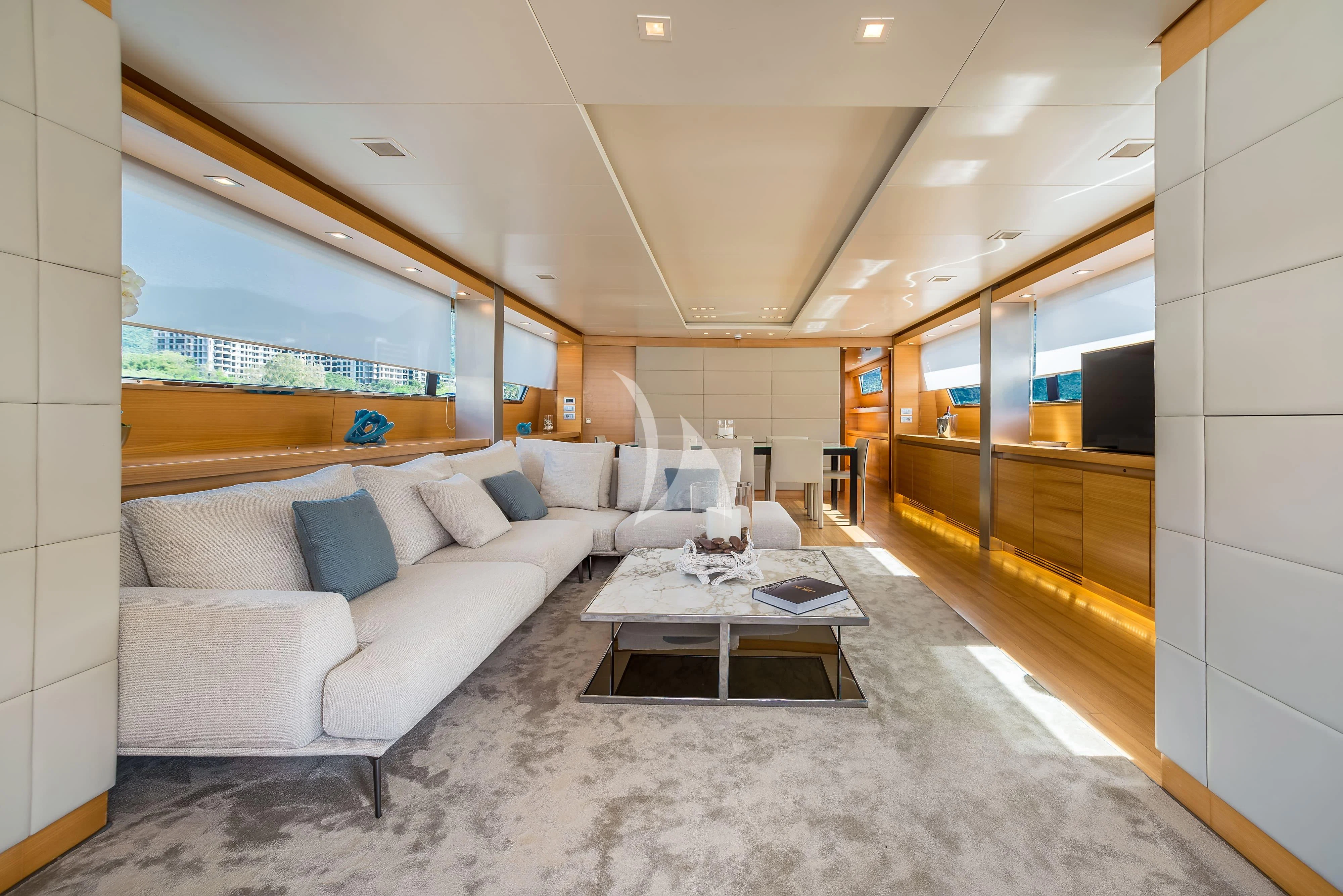 a living room with a large white couch and a large window aboard PERTULA Yacht for Sale