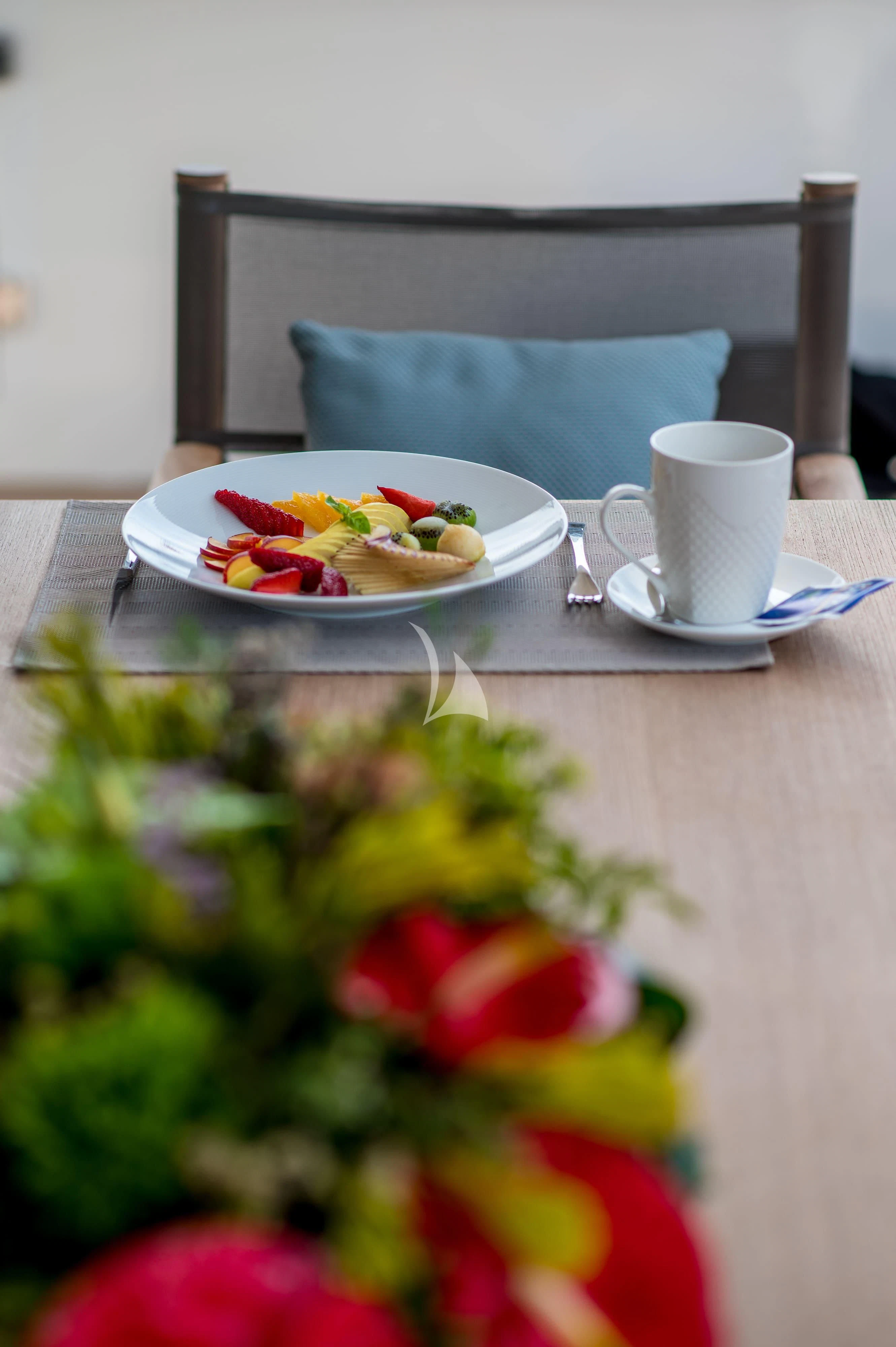 a plate of food and a cup of coffee on a table aboard PERTULA Yacht for Sale