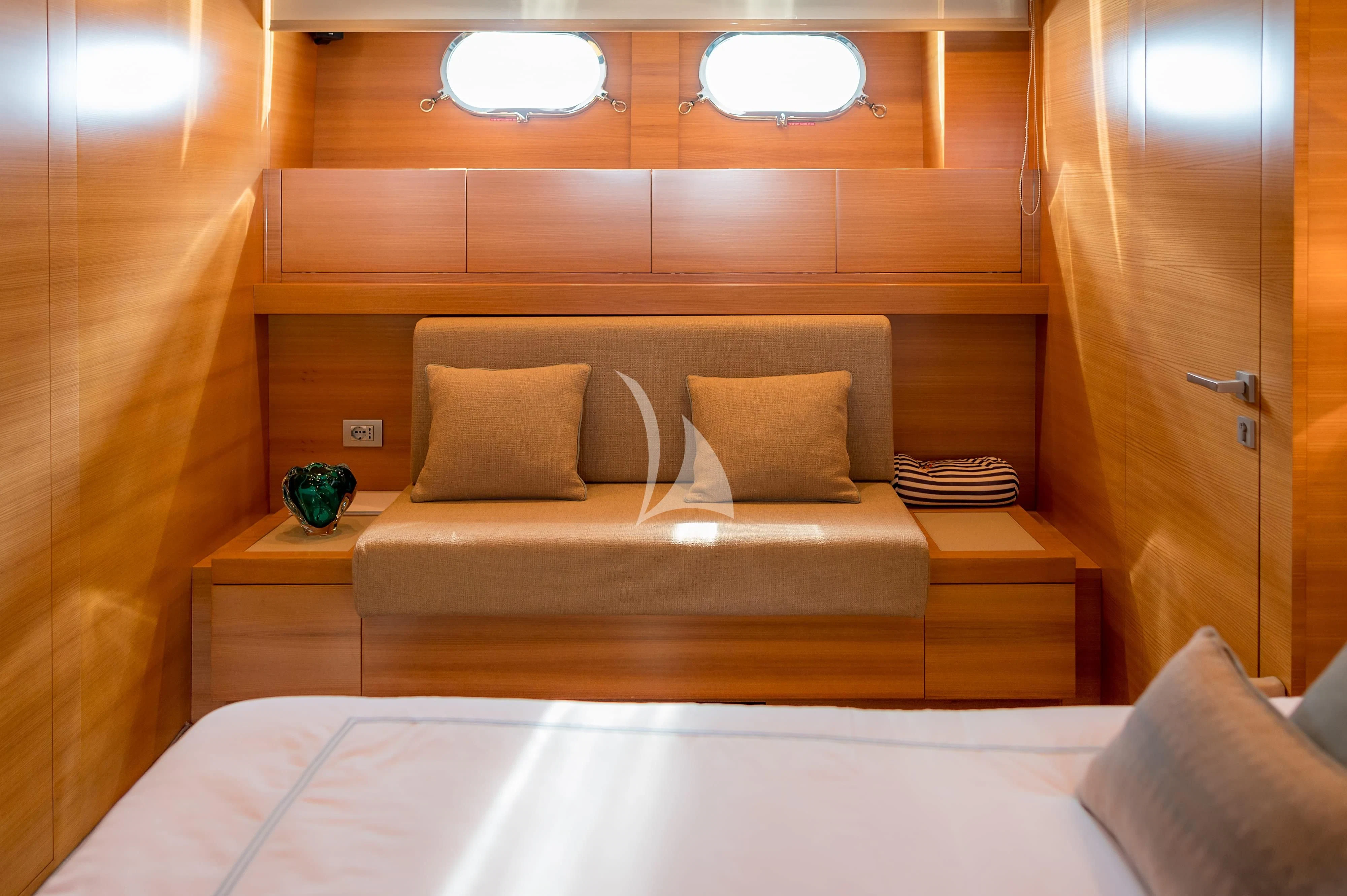 a bed with a white couch aboard PERTULA Yacht for Sale