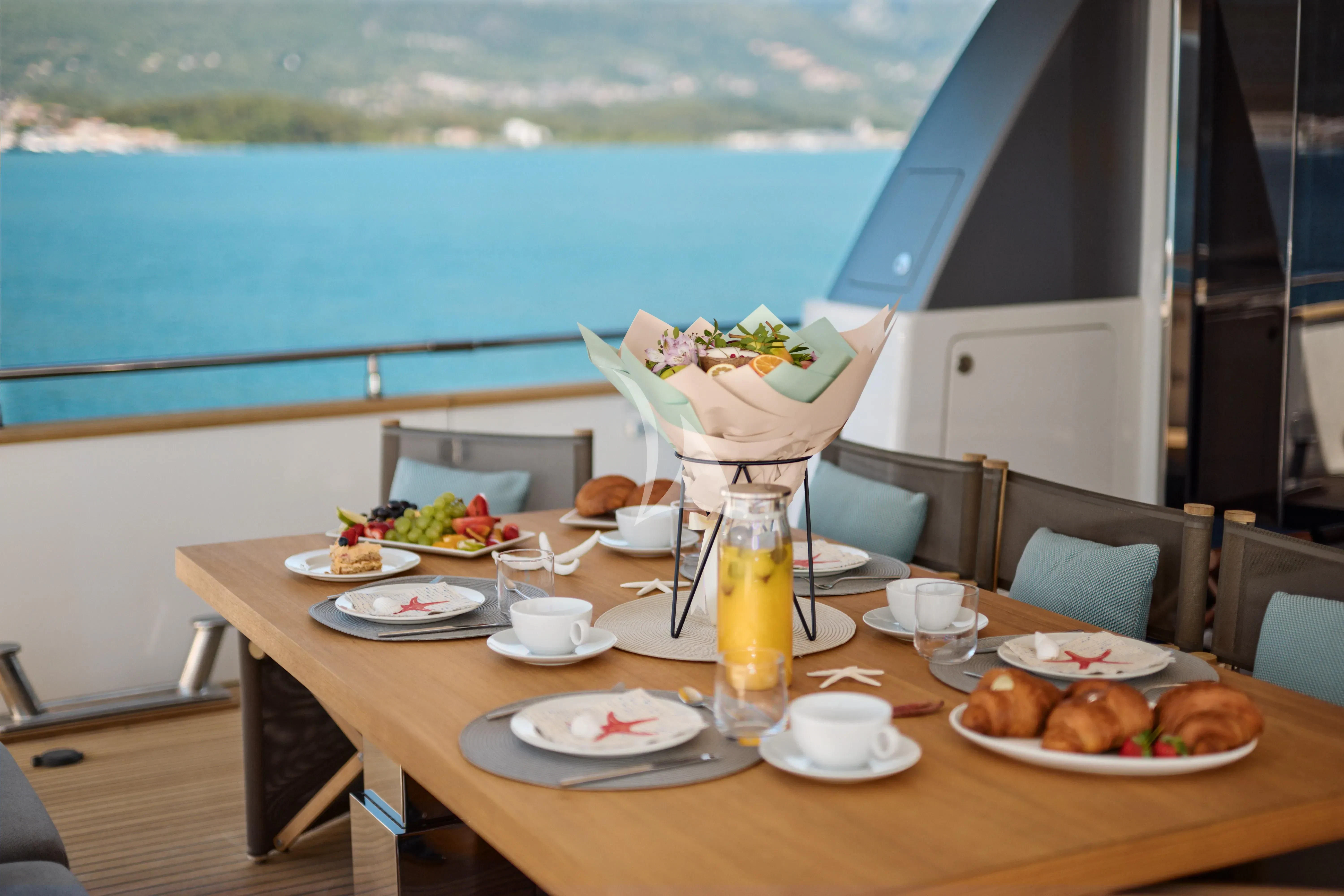 a table with plates and food on it aboard PERTULA Yacht for Sale