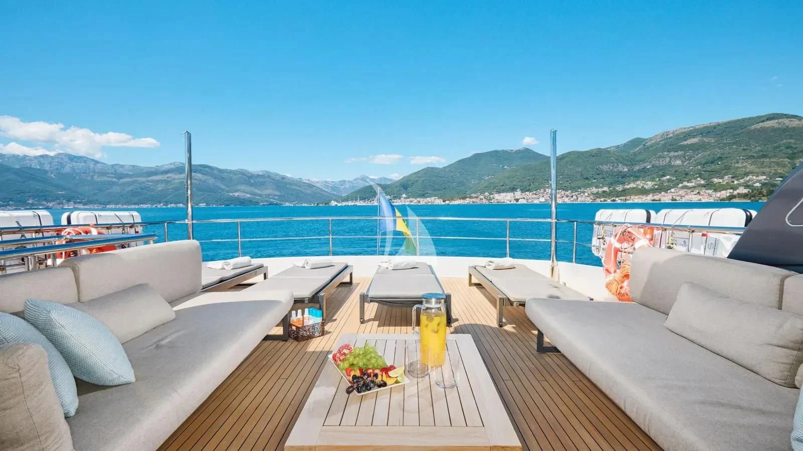 a deck with a view of the ocean and mountains aboard PERTULA Yacht for Sale