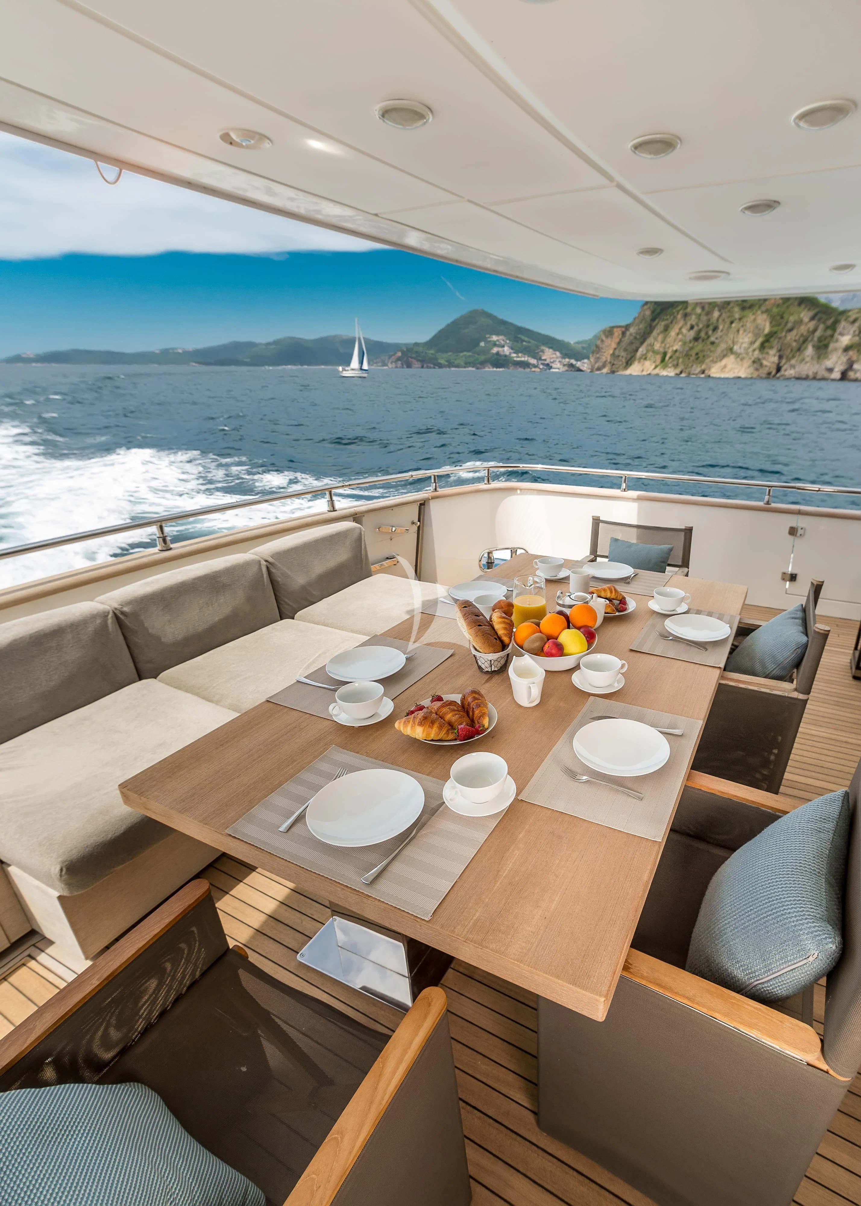a table with plates and food on it aboard PERTULA Yacht for Sale