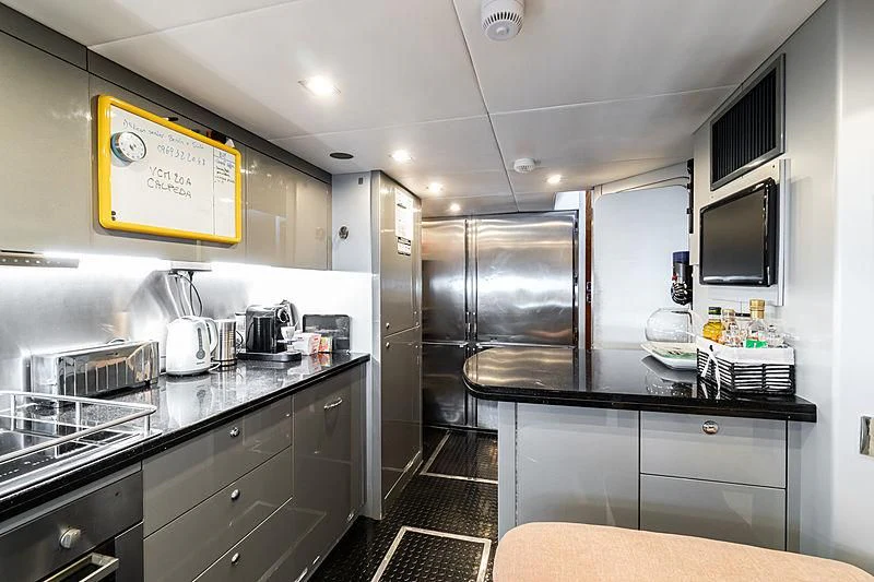 a kitchen with a black counter and black cabinets aboard EYE Yacht for Sale