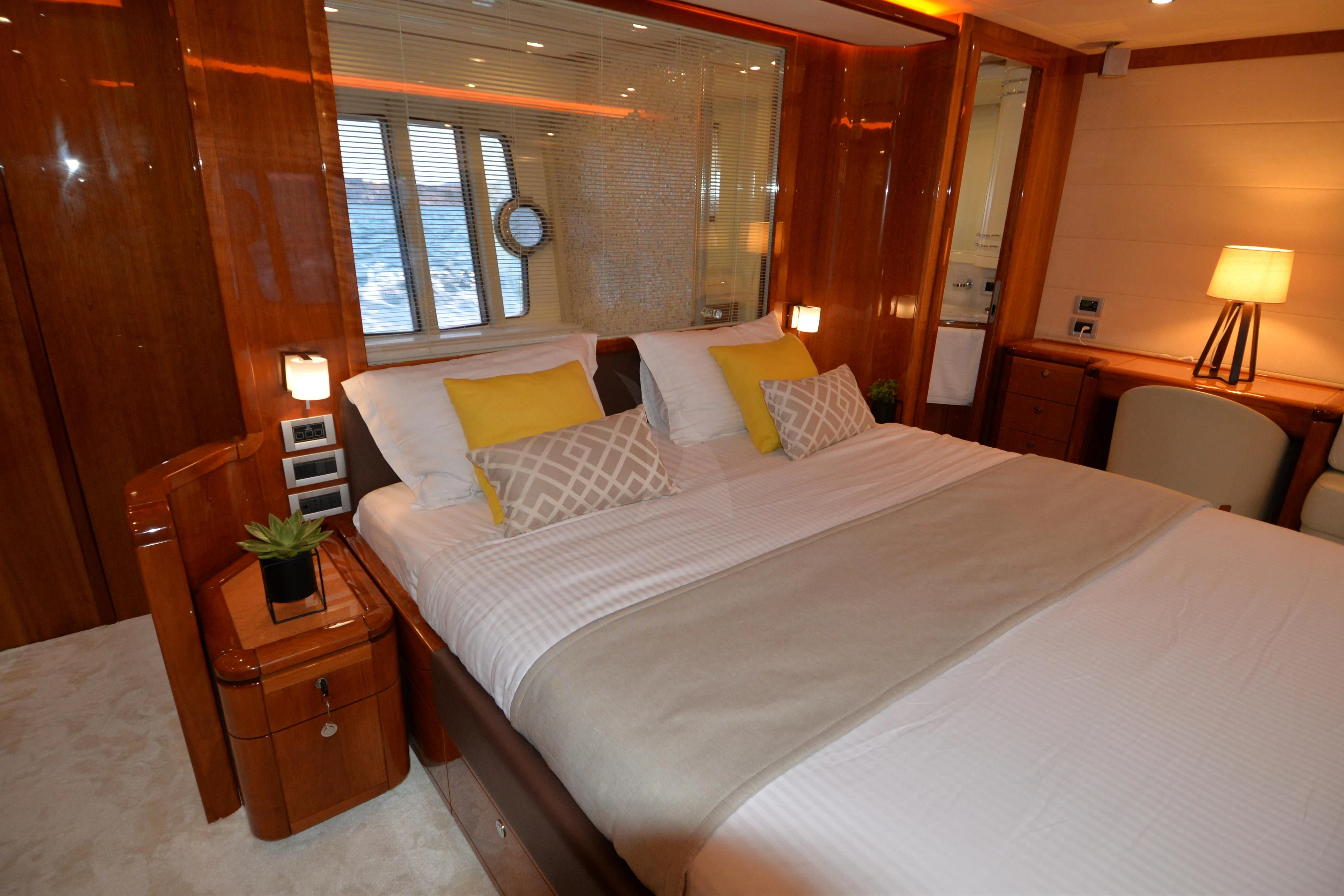 a bed with a white sheet and pillows in a room with wood walls aboard ASTARTE Yacht for Sale