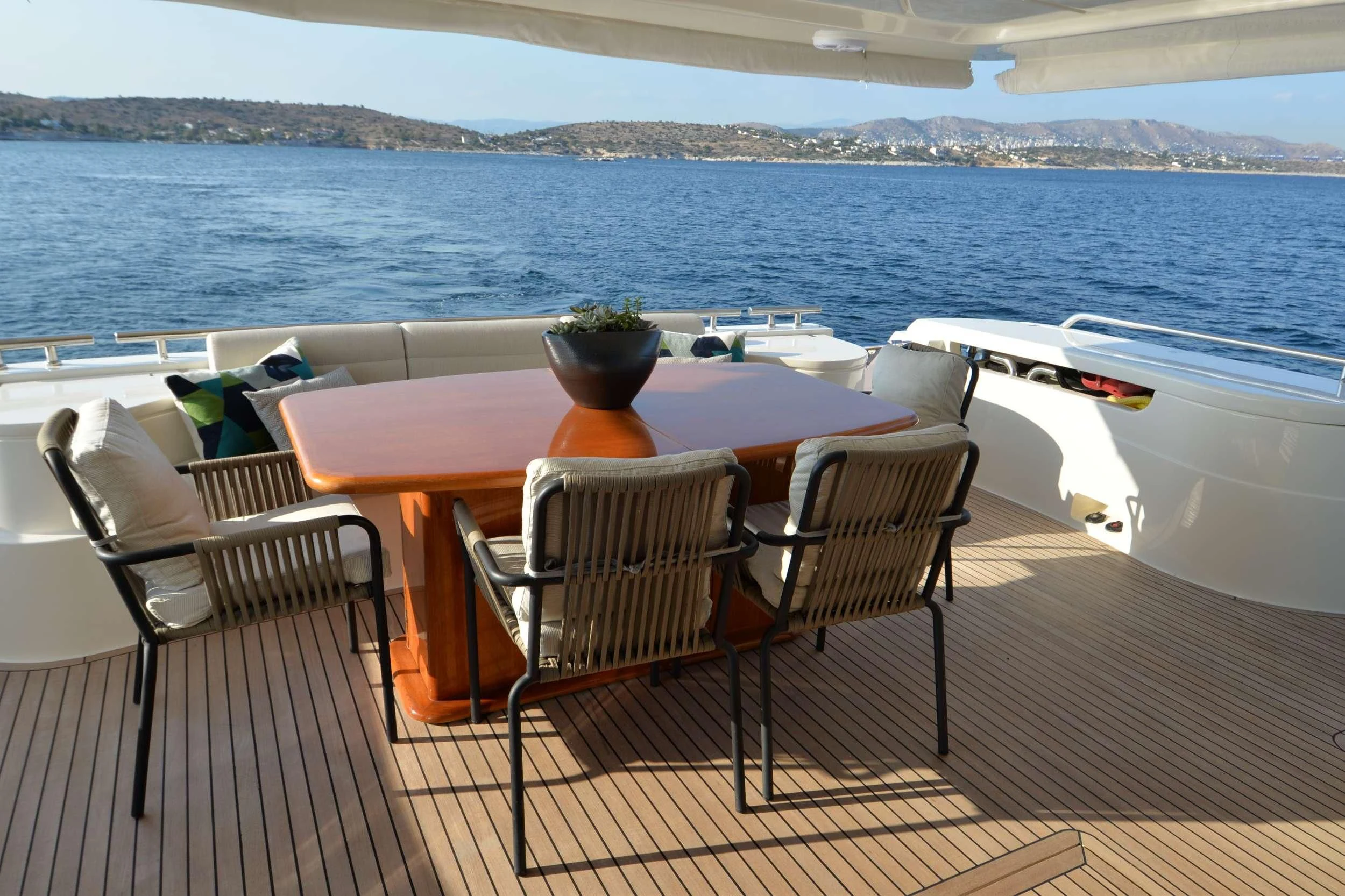 a table and chairs on a deck overlooking a body of water aboard ASTARTE Yacht for Sale