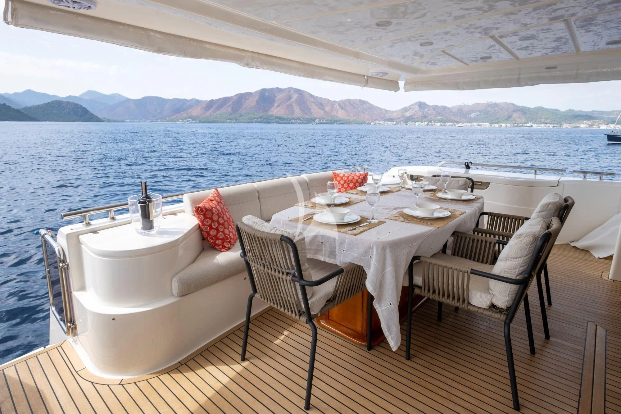 a table and chairs on a deck overlooking a body of water aboard ASTARTE Yacht for Sale
