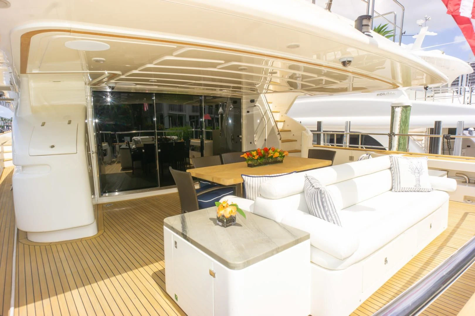 a room with a large white bed and a table aboard ADAR Yacht for Sale