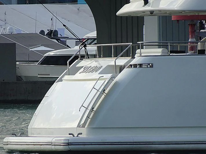 a white yacht in a harbor aboard ADAR Yacht for Sale