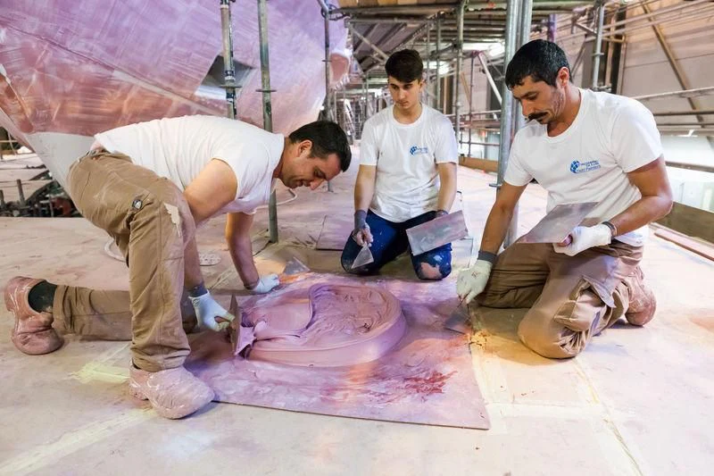 a group of men working on a large piece of meat aboard MASA Yacht for Sale
