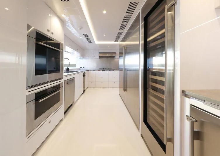 a large kitchen with white cabinets aboard A SALT WEAPON Yacht for Charter