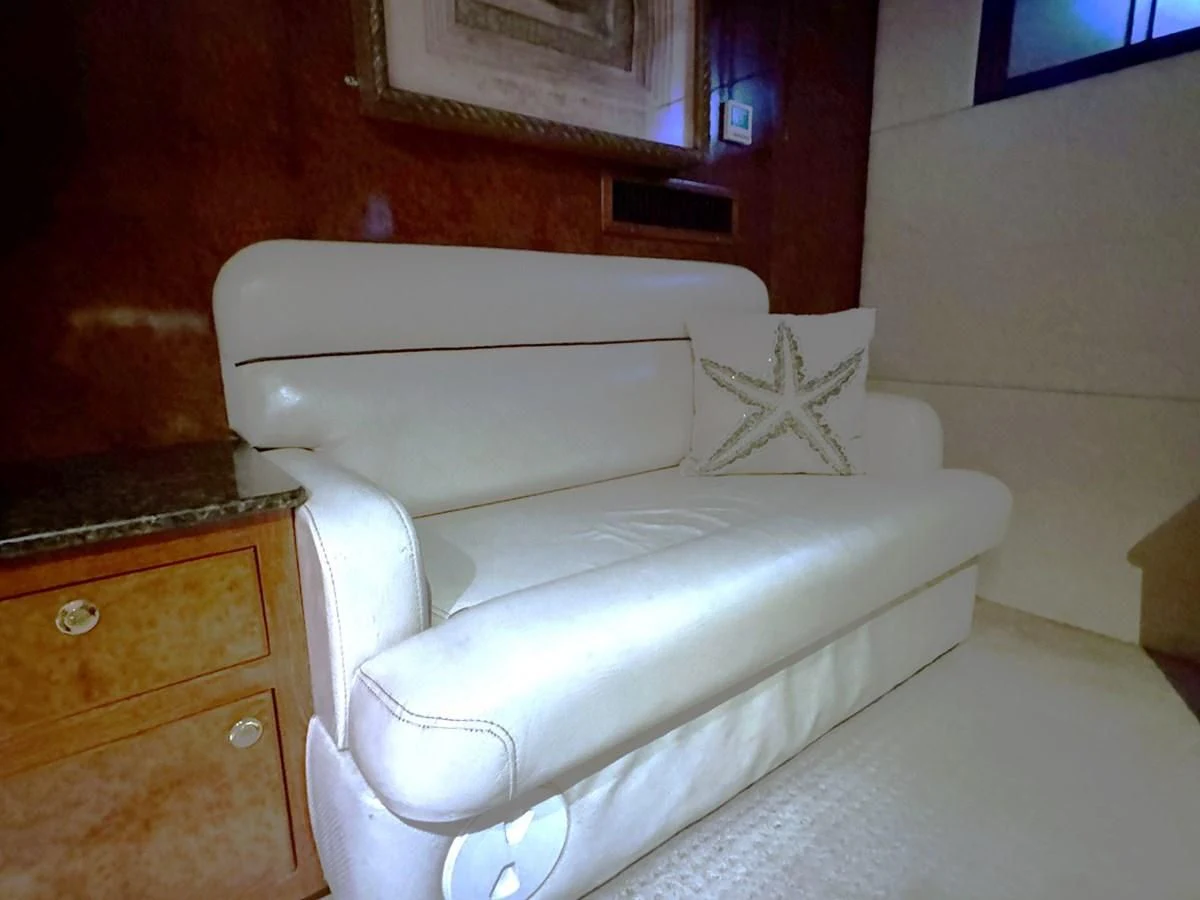 a white couch in a room aboard DREAMCHASER Yacht for Sale