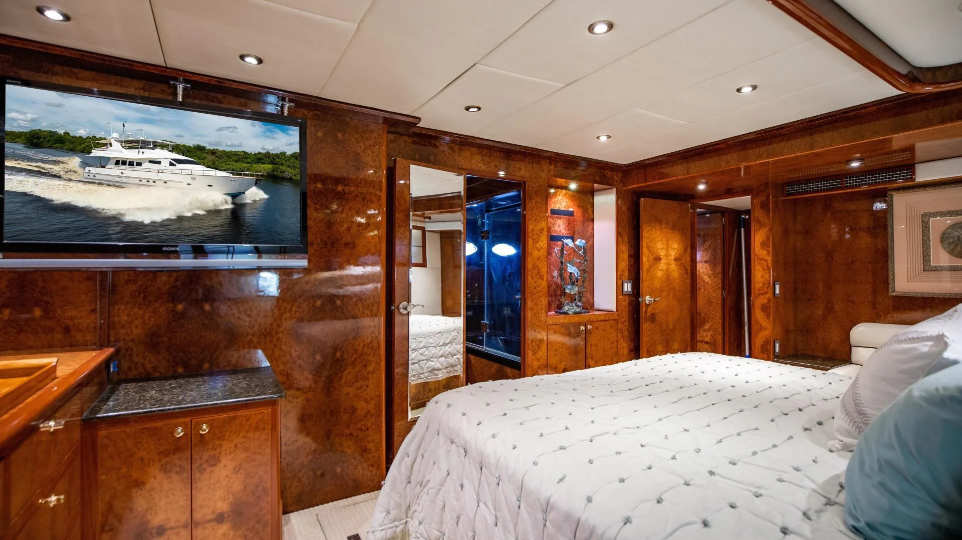 a room with a bed and a television aboard DREAMCHASER Yacht for Sale