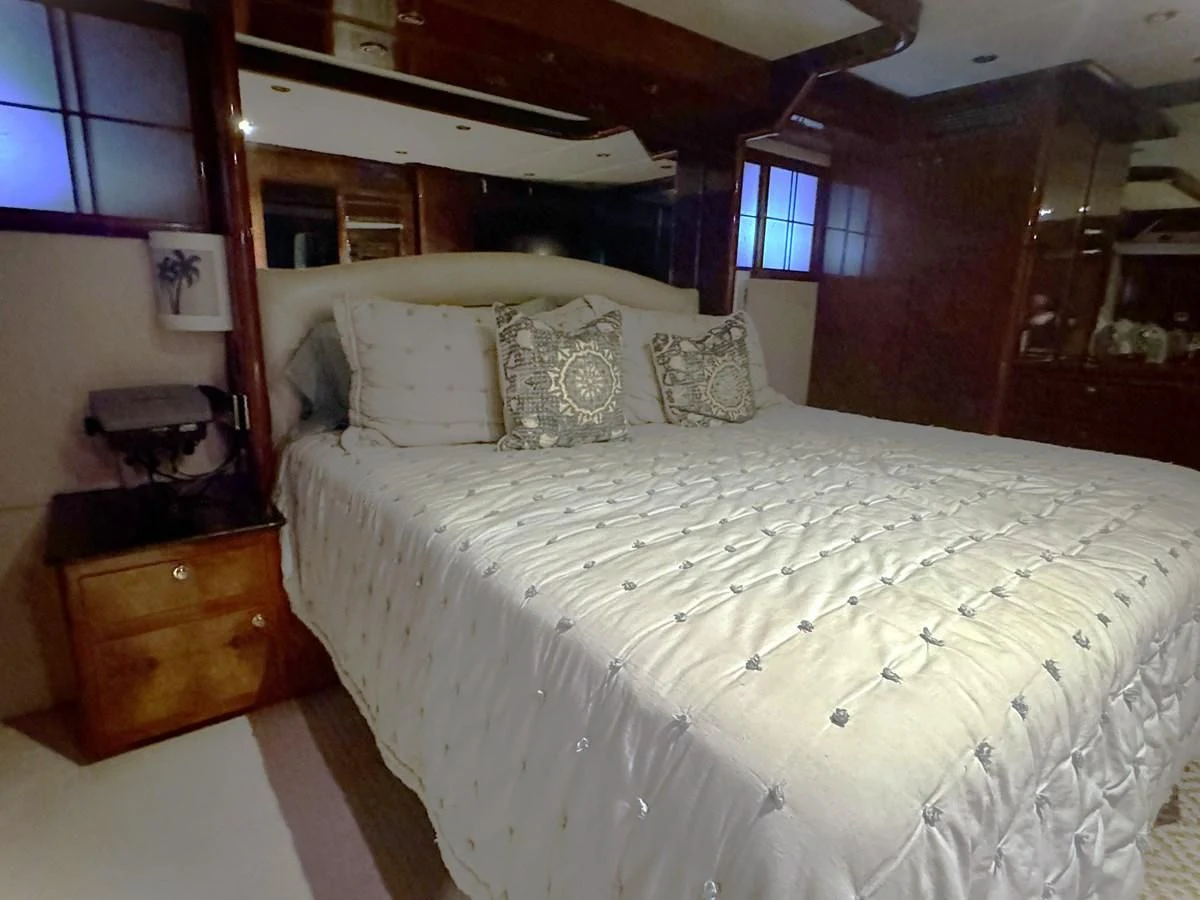 a bed with white sheets aboard DREAMCHASER Yacht for Sale